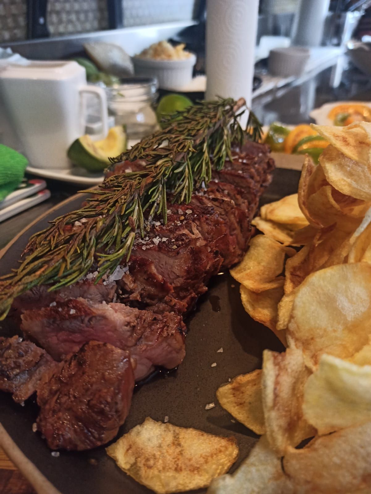 Un primer plano de un sándwich en un plato con papas fritas en el fondo.