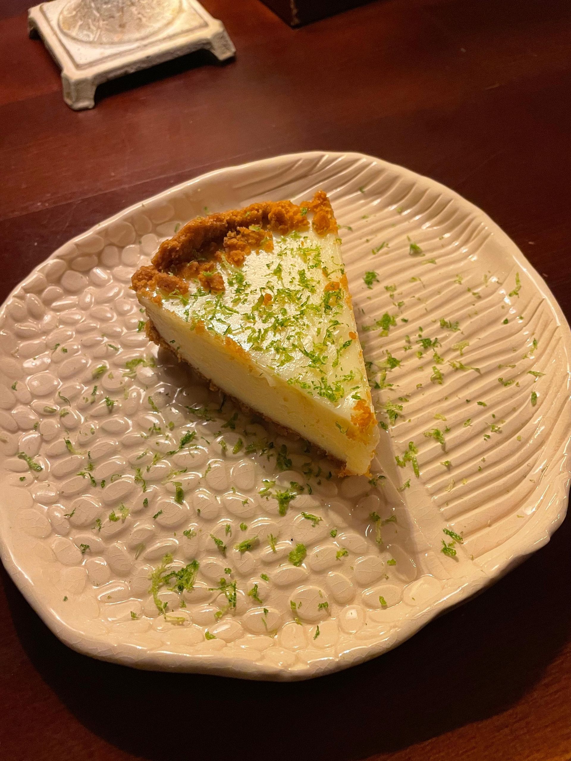 Una rebanada de pastel está en un plato blanco sobre una mesa.