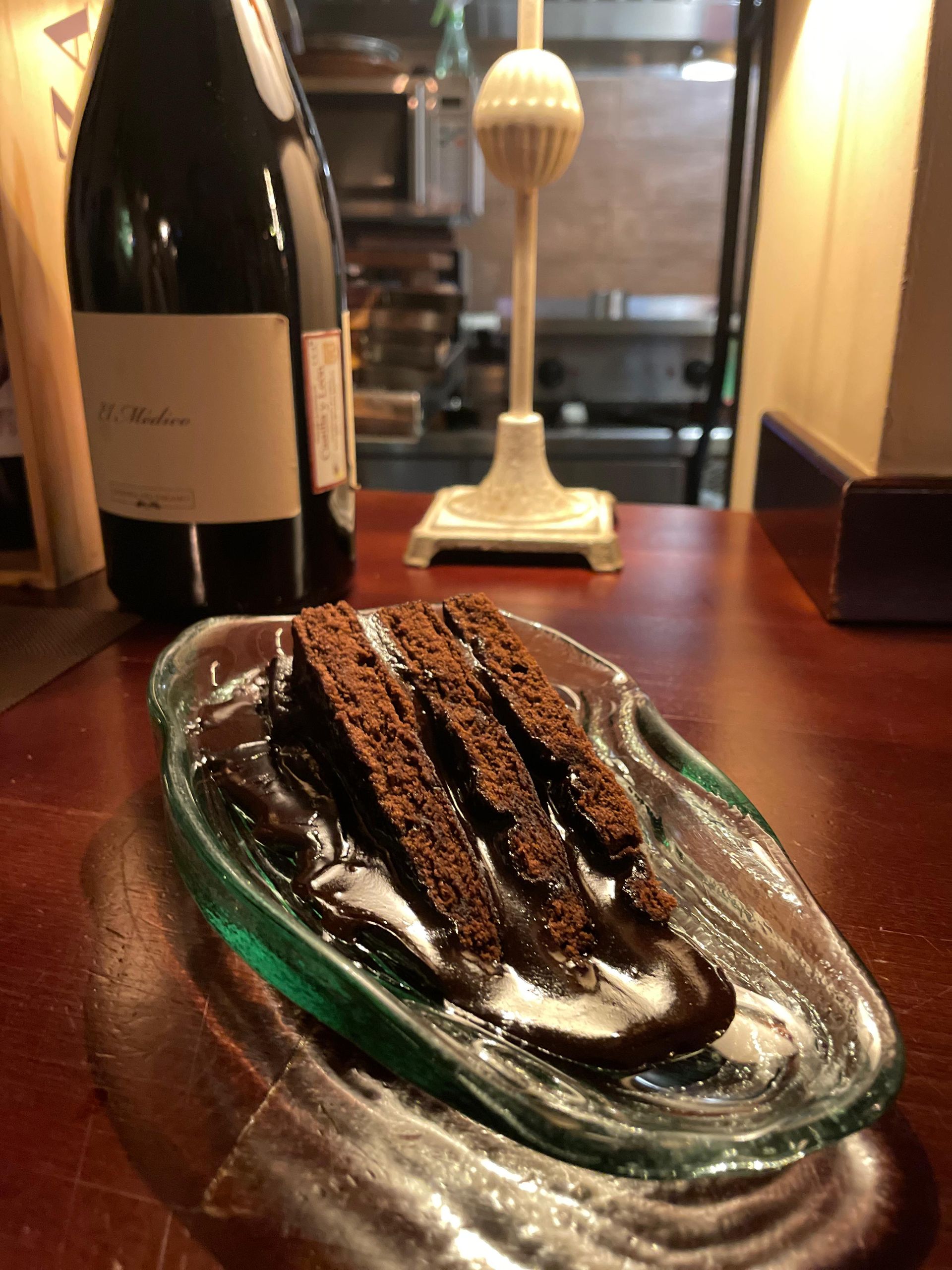 Una rebanada de tarta de queso con salsa de caramelo en un plato negro.