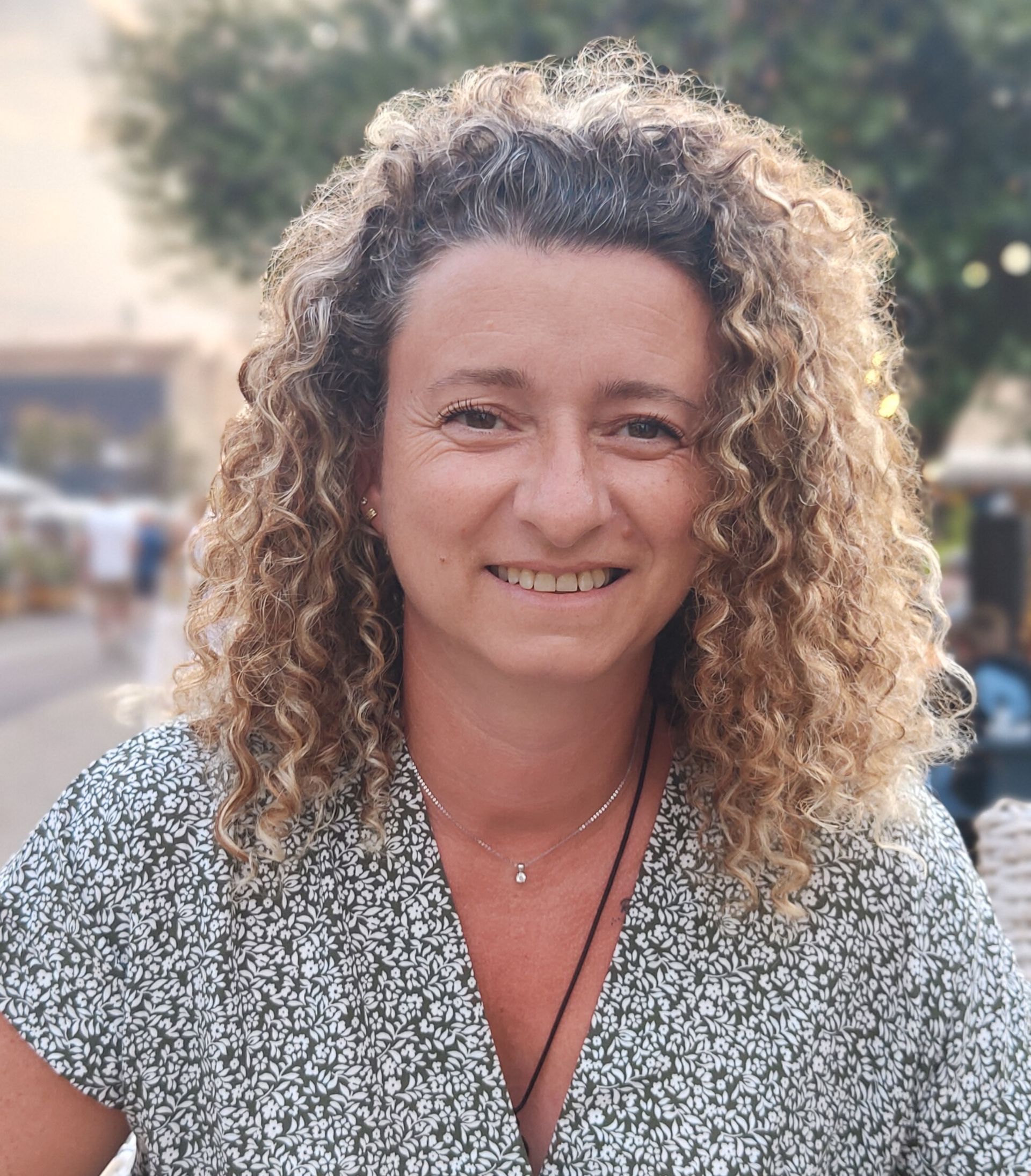 Une femme aux cheveux longs et frisés : praticienne en hypnose