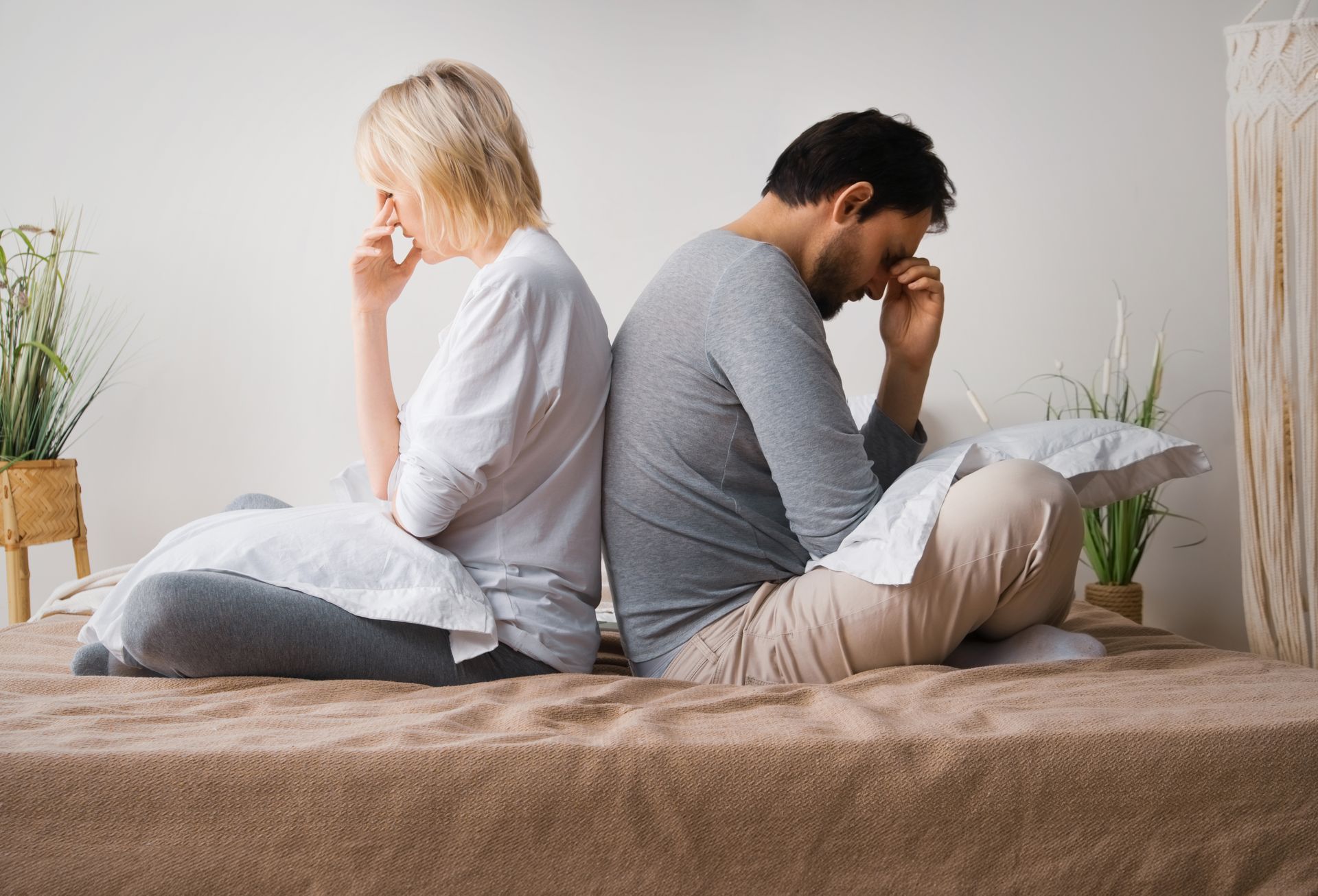 Un couple se tournant le dos sur un lit