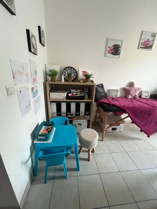 Du mobilier et une table avec des cadres sur les murs du cabinet de thérapie