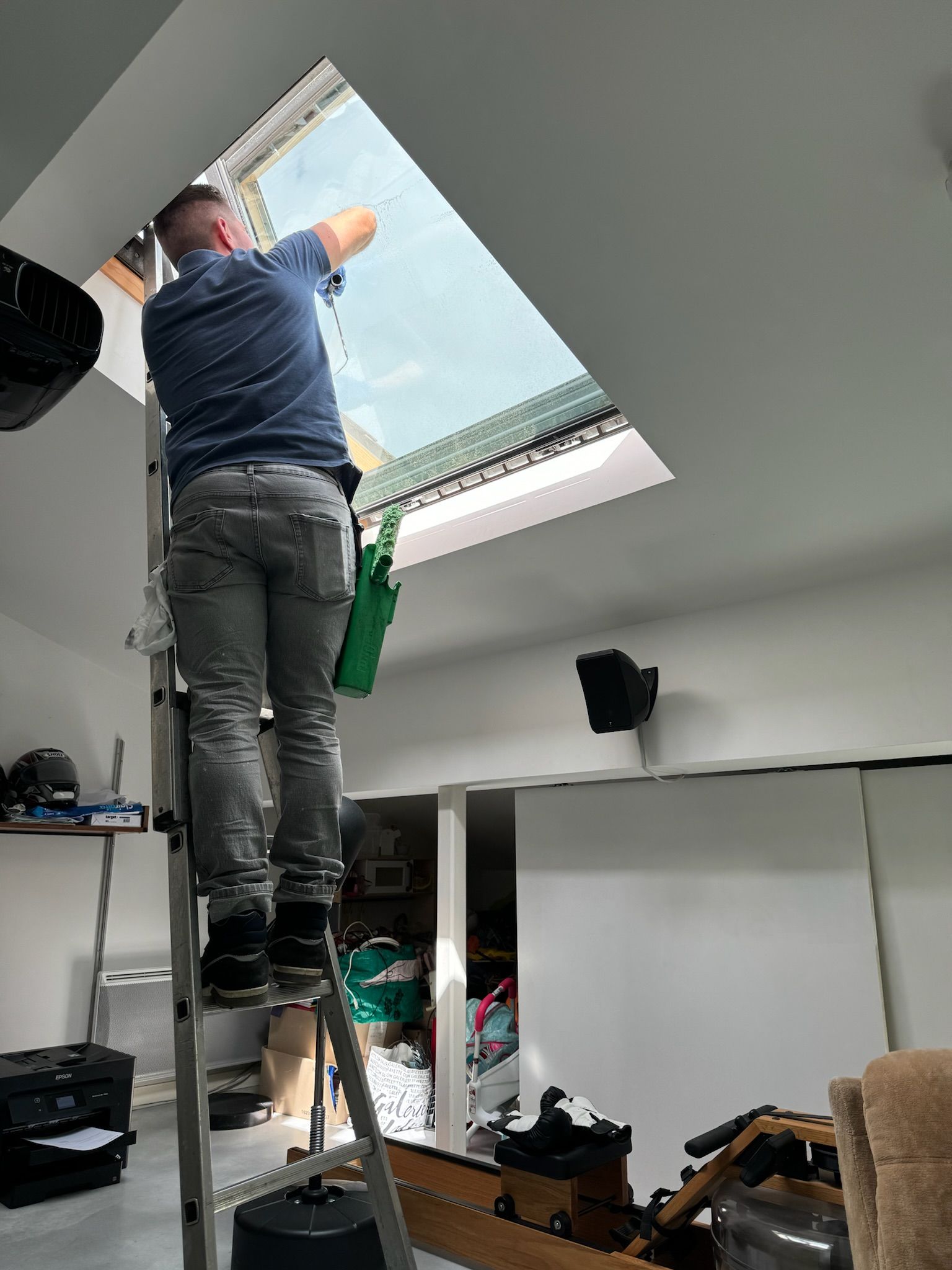 Agent d'entretien lavant une fenêtre de toit