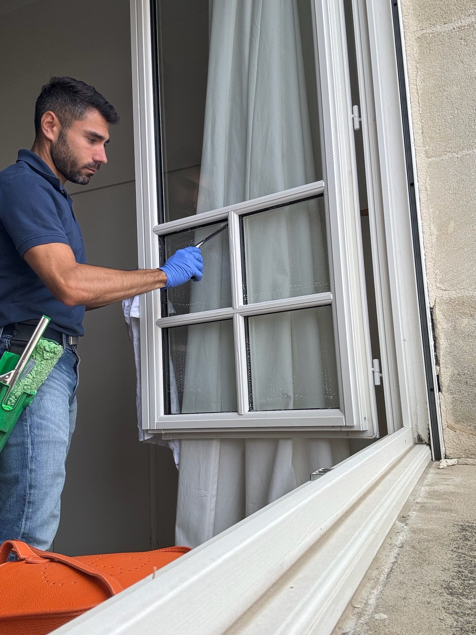 Anthony Pereira nettoyant les vitres d'une fenêtre
