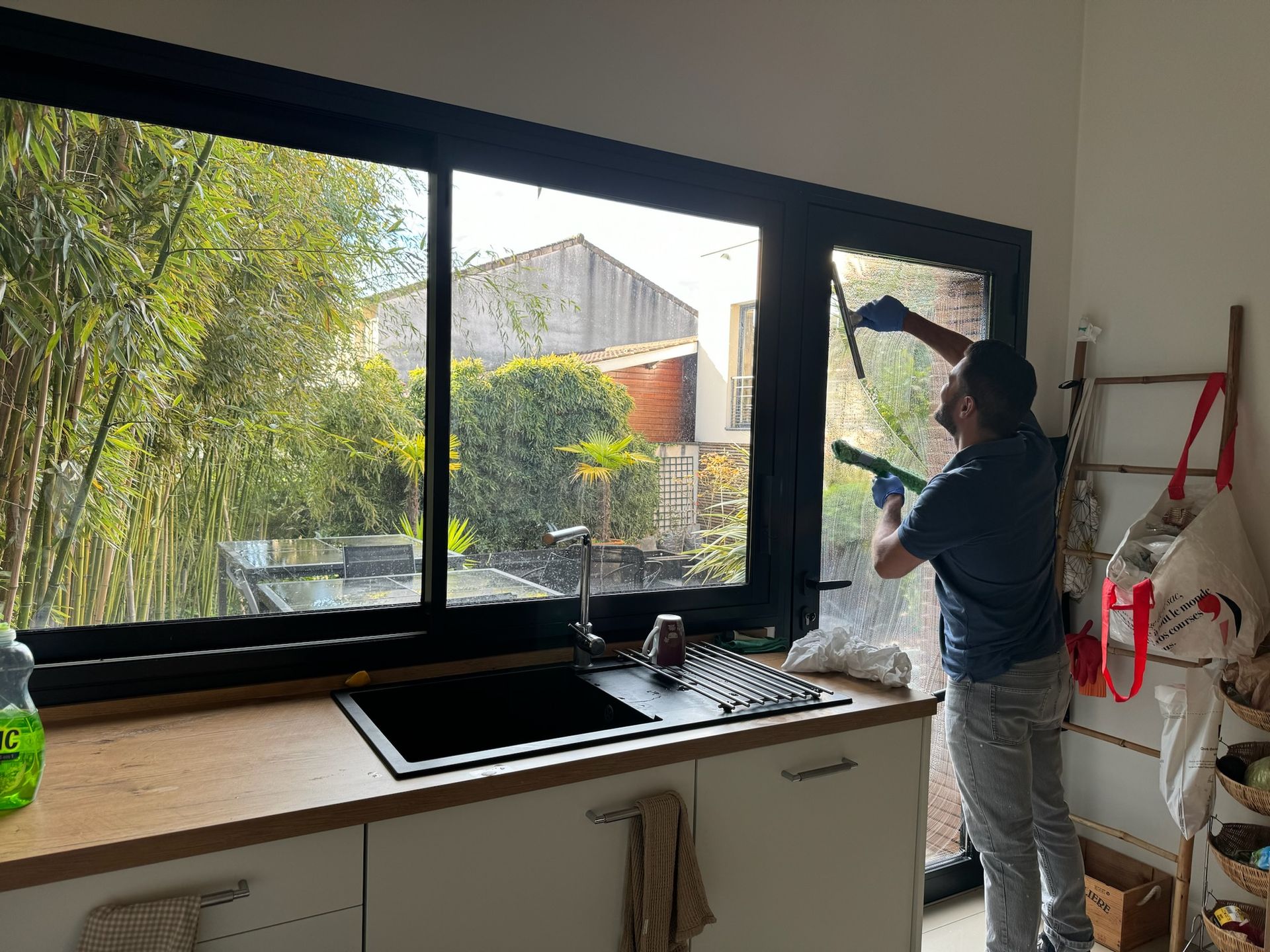 Agent d'entretien lavant les vitres côté intérieur d'une fenêtre