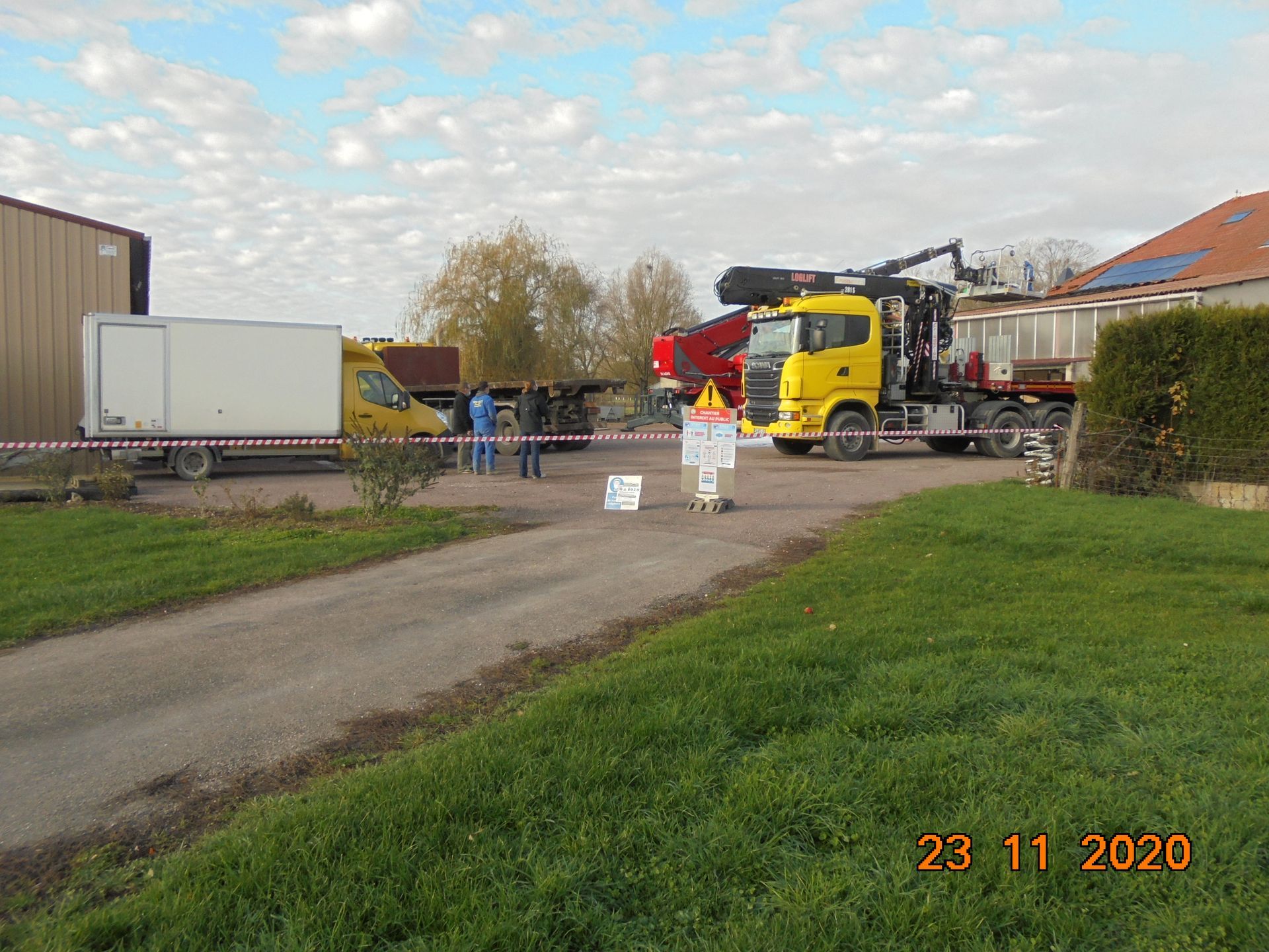 Zone de chantier délimité à la rubalise et camion avec cabine jaune derrière
