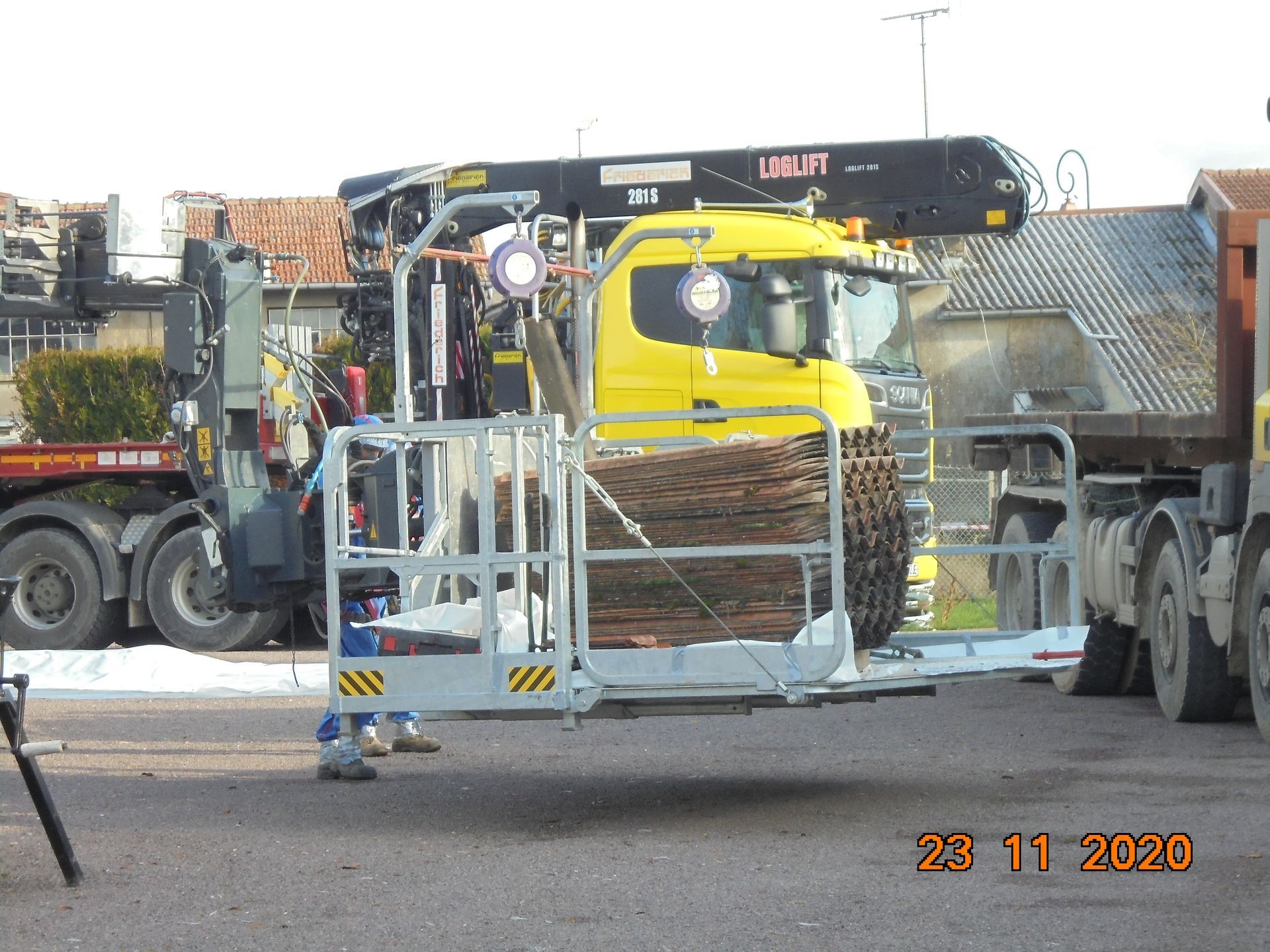 Grue en train de soulever un tas d'ancienne tuile en amiante 