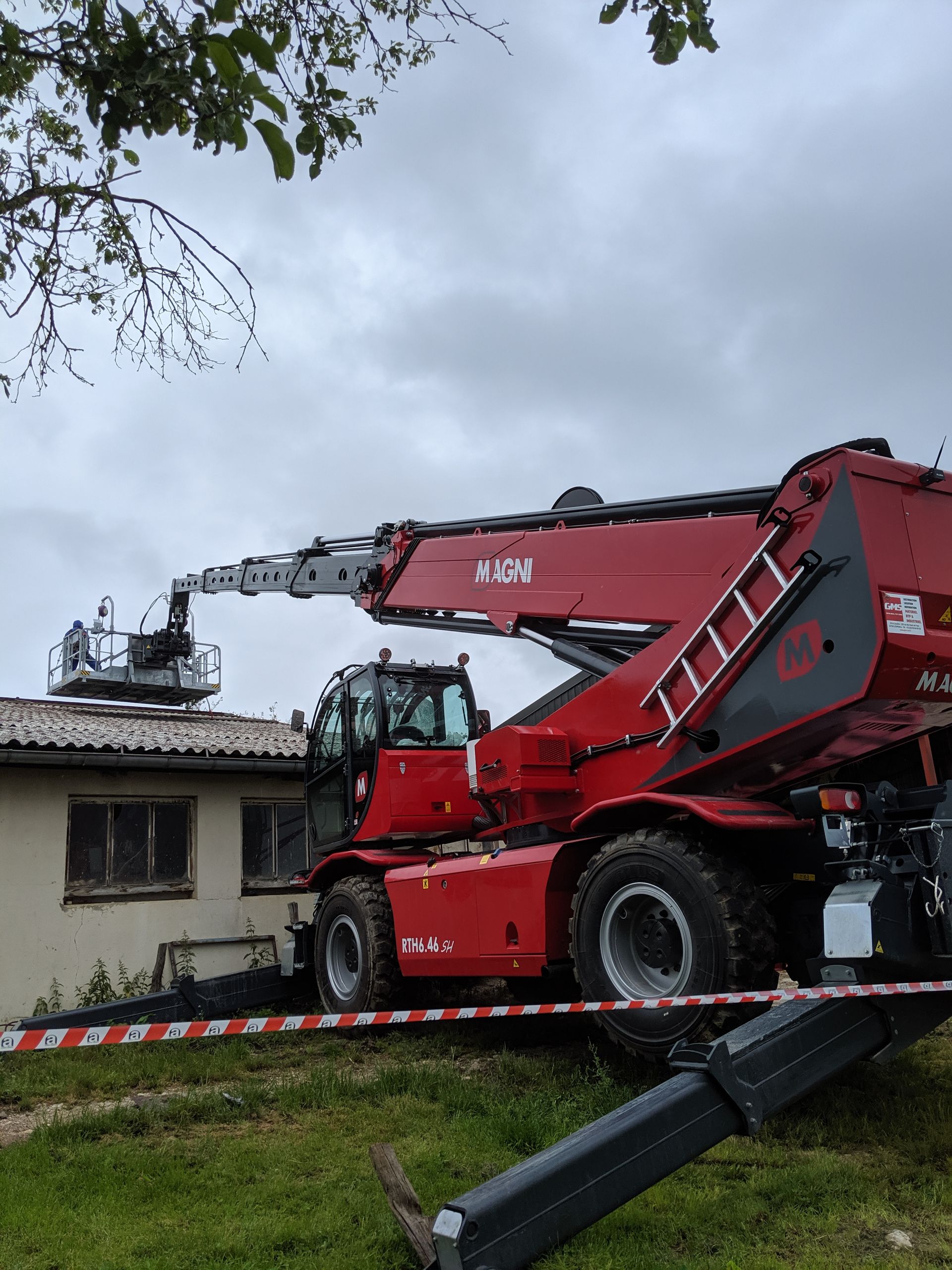 Grue rouge télescopique avec nacelle intervention sur un toit