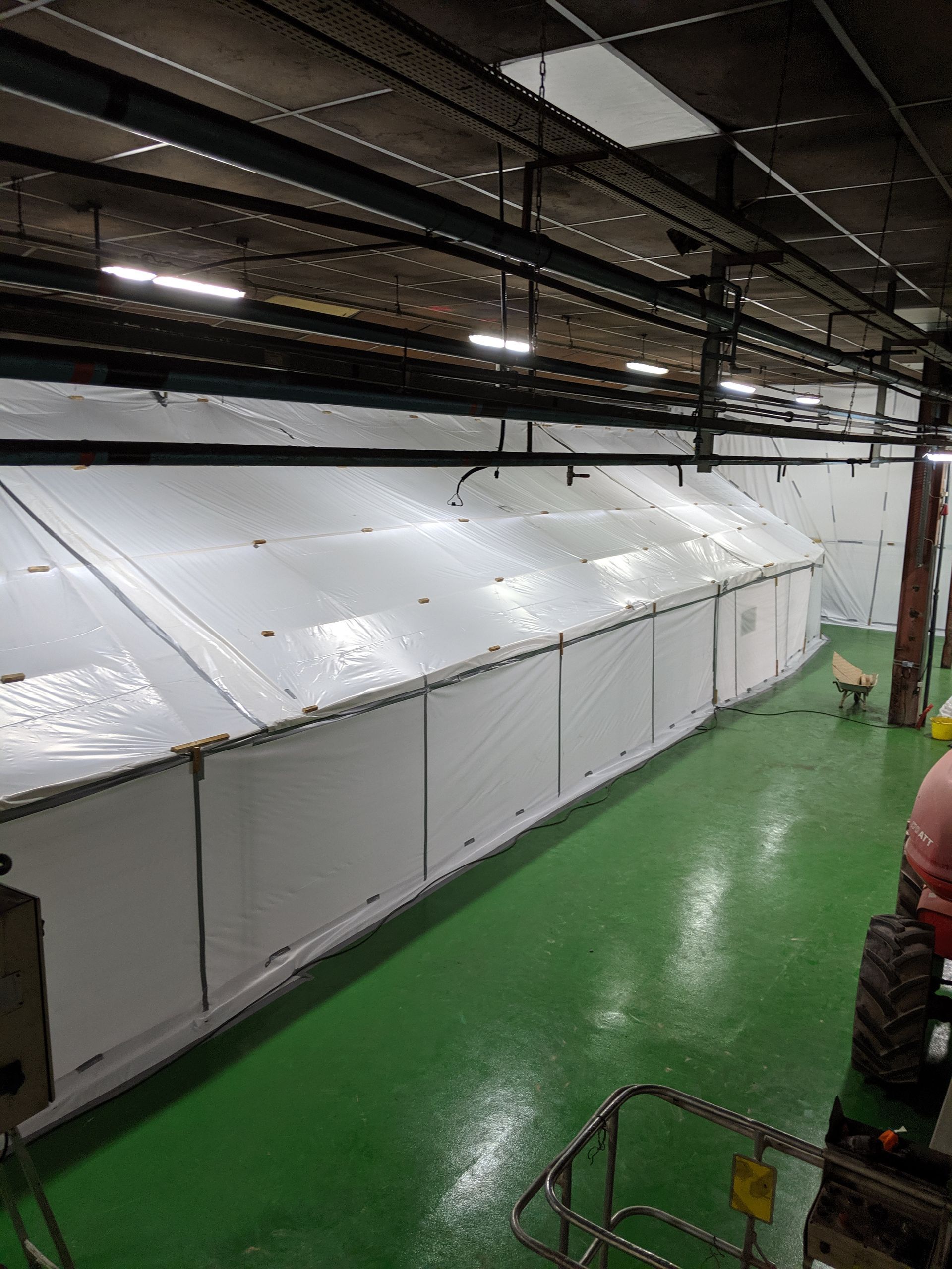 Structure en tente blanche à l'intérieur d'une usine pour préparer le désamiantage du sol d'une ancienne usine