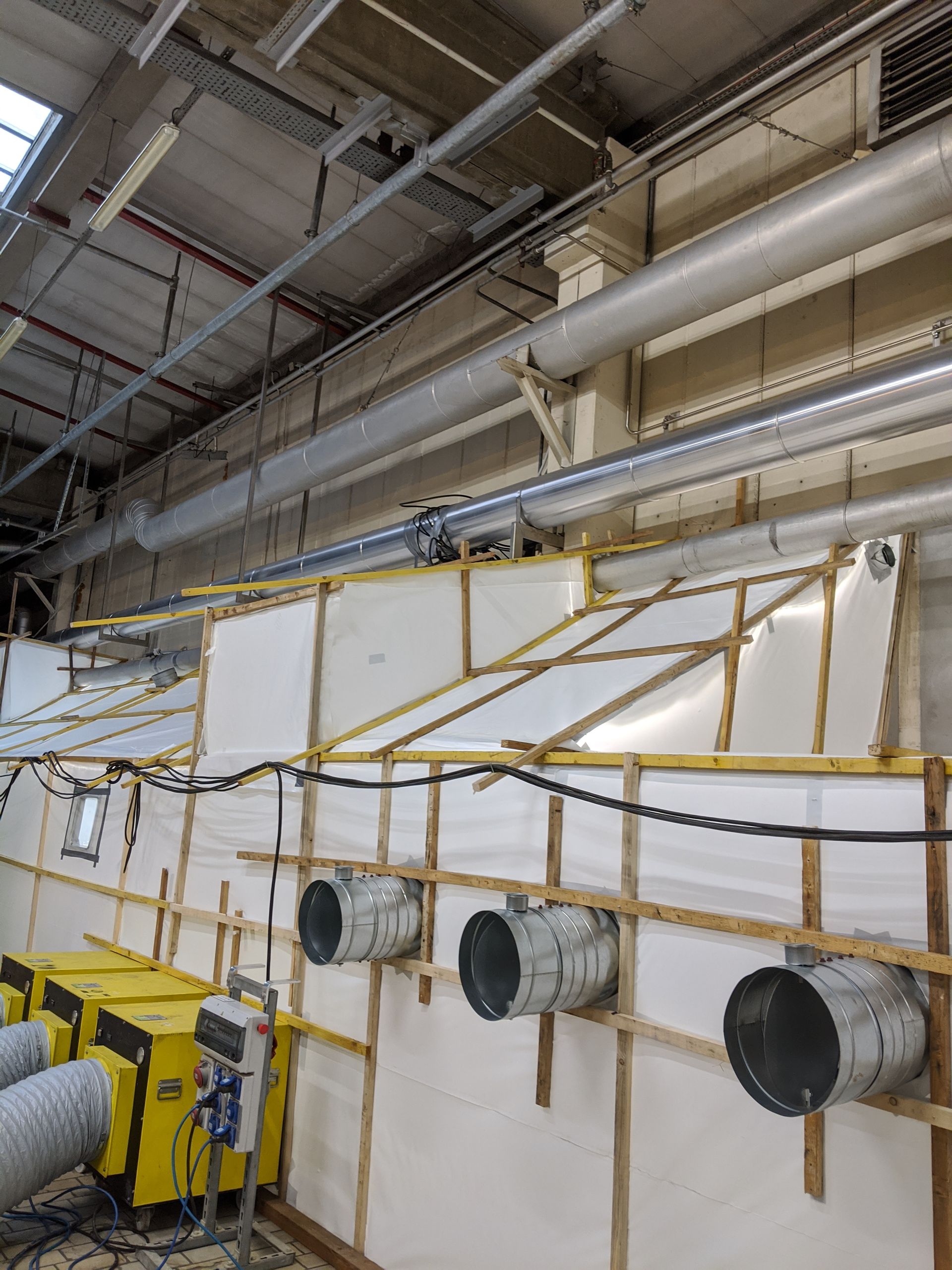 Installation d'une structure blanche et un système de ventilation pour préparer le désamiantage du sol