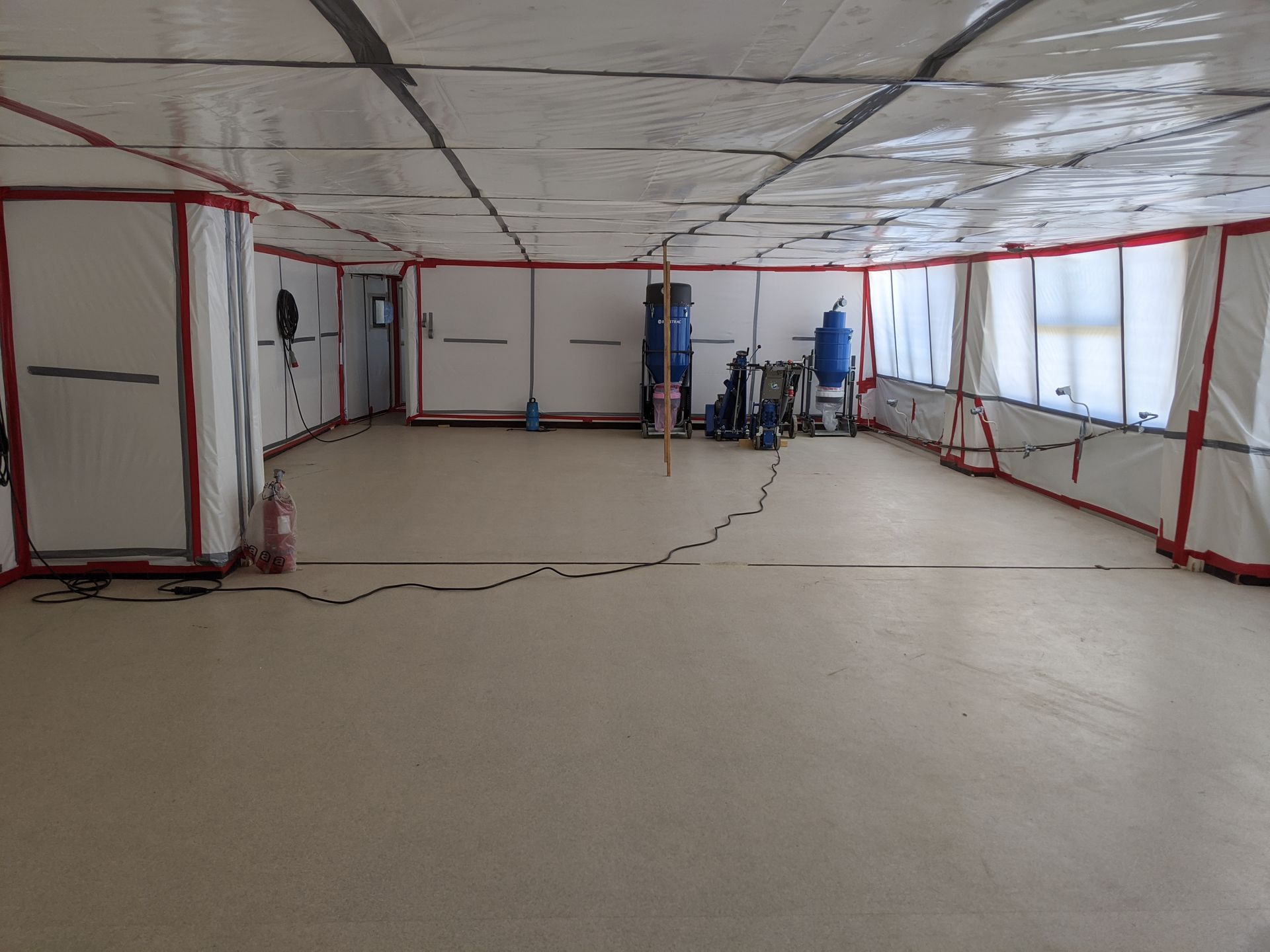 Bâche blanche pour isoler la partie dangereuse d'un bâtiment avec des appareils pour détruire le sol qui contient des matériaux dangereux