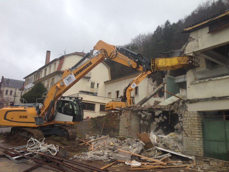 Pelleteuse jaune en train de détruire d'ancienne habitation