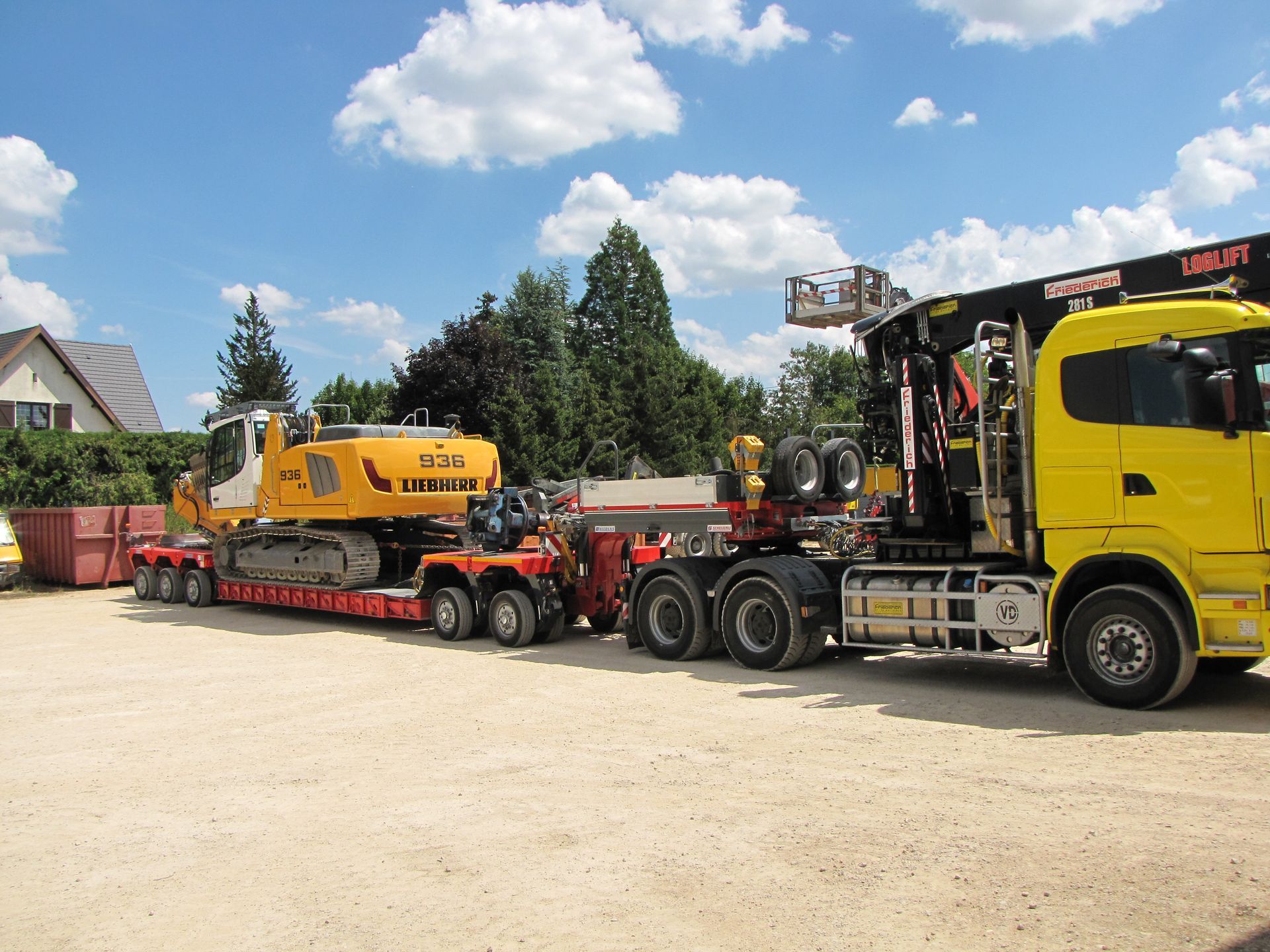 Tractopelle Liebherr jaune sur la remorque d'un camion avec une cabine jaune