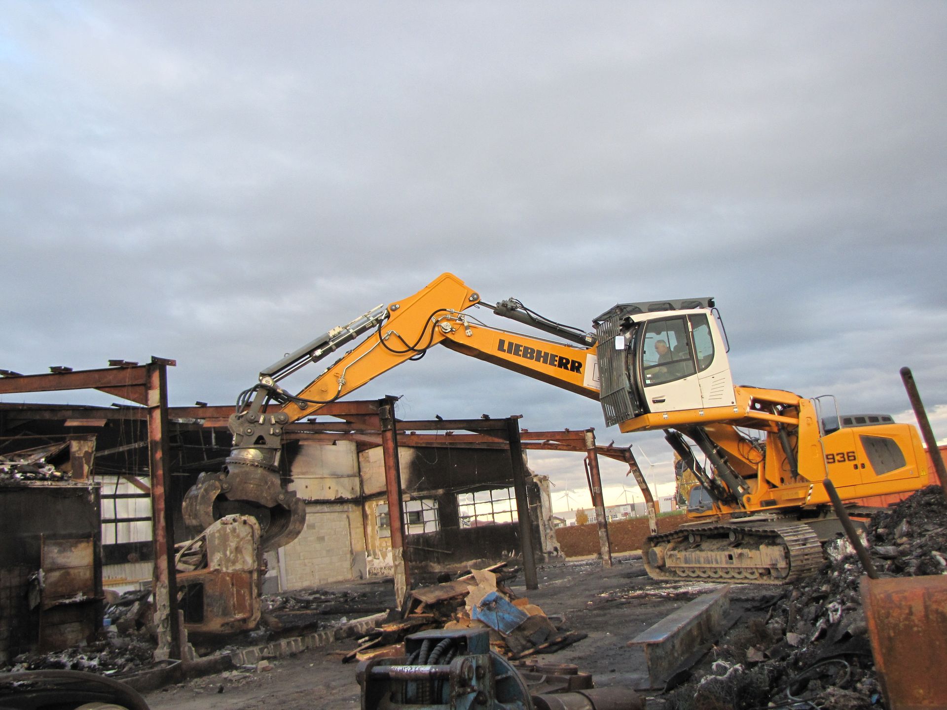 Tractopelle Liebherr jaune déployé avec pince