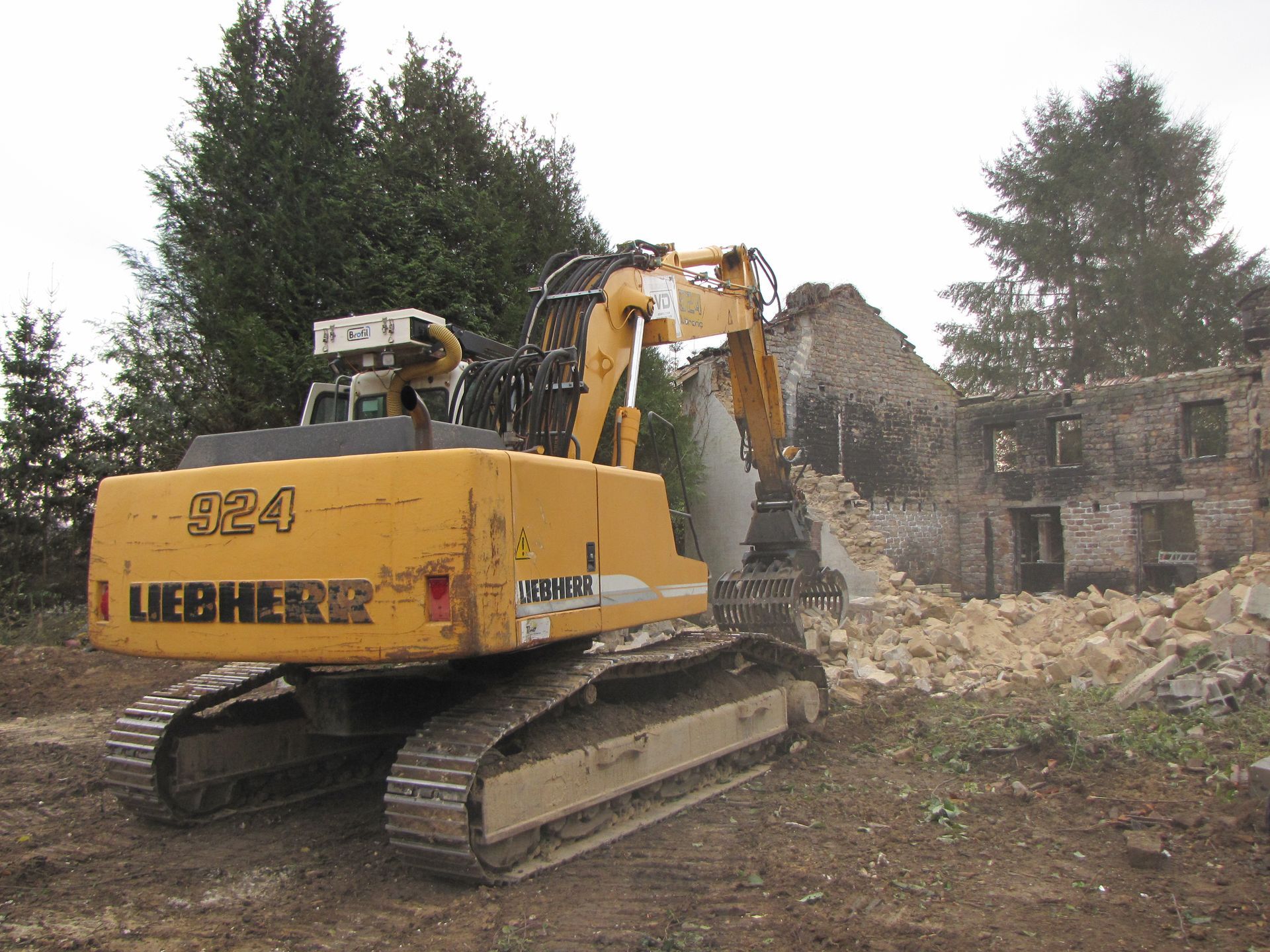 Tractopelle Liebherr jaune avec pince