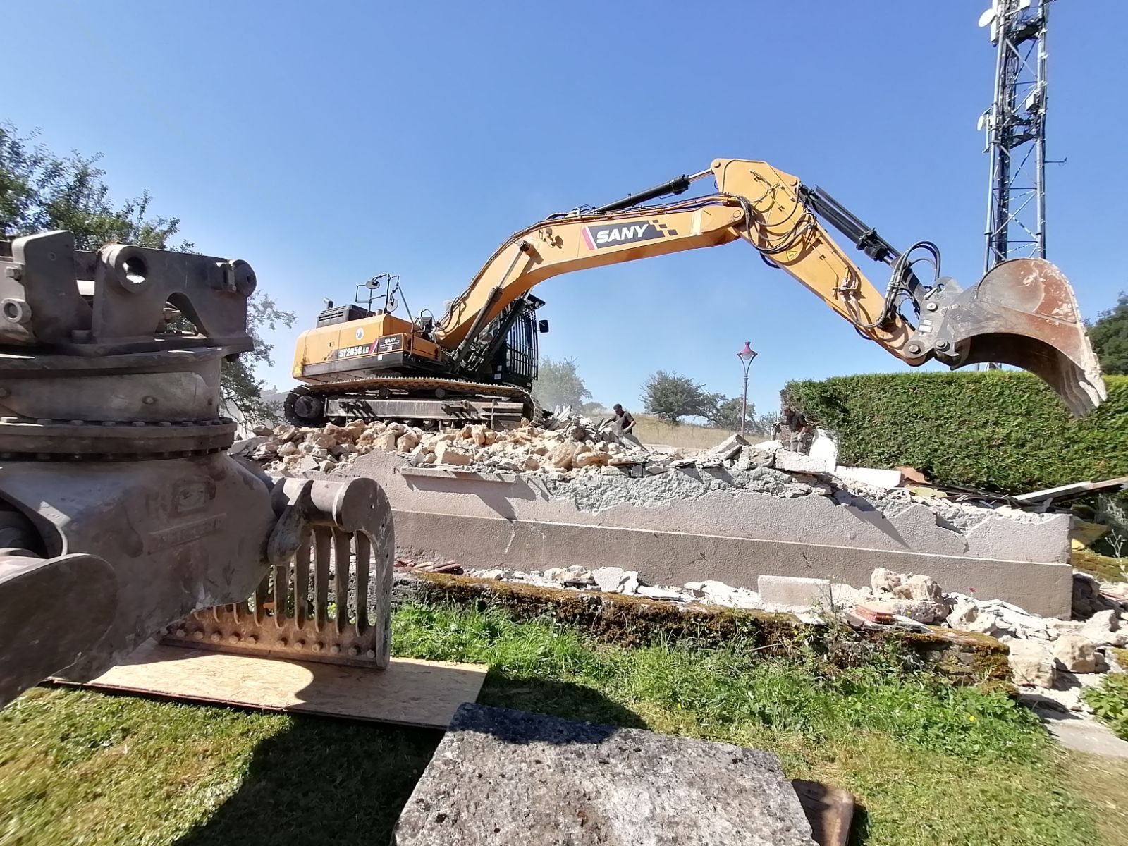 Pelleteuse de destruction avec godet déployé sur un tas de décombre
