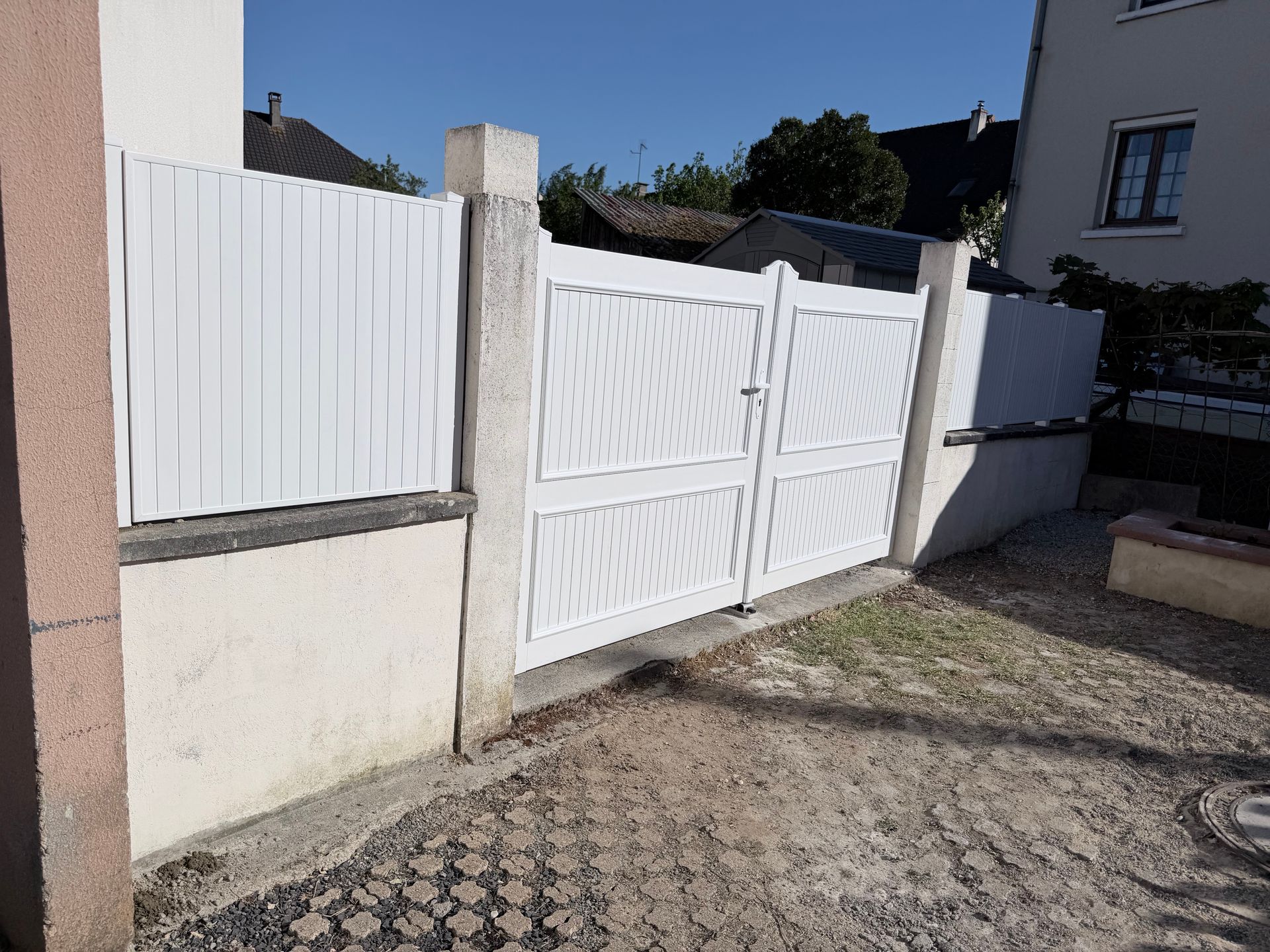 Portail et clôture blancs.
