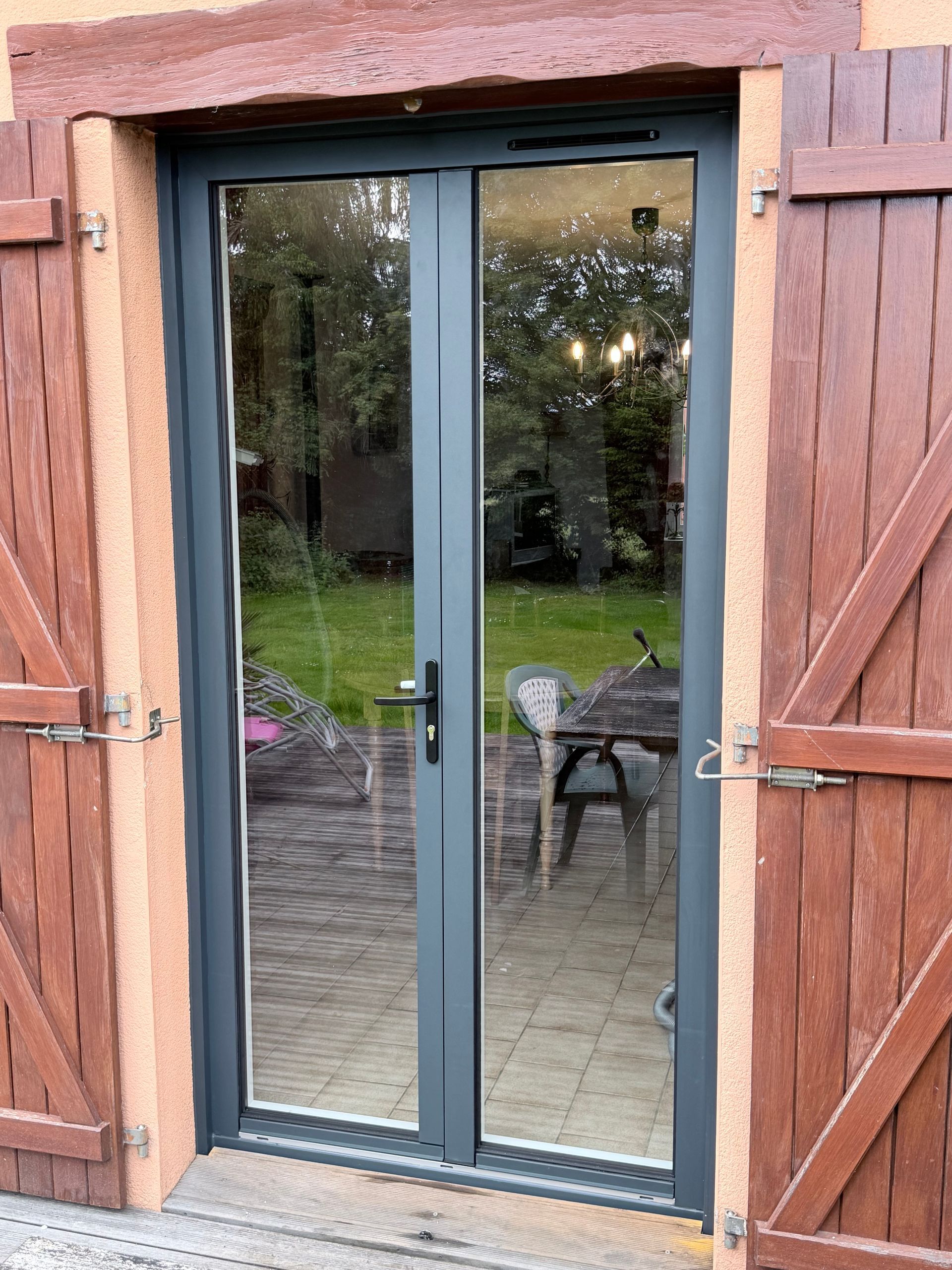 Portes-fenêtres vitrées avec volets.