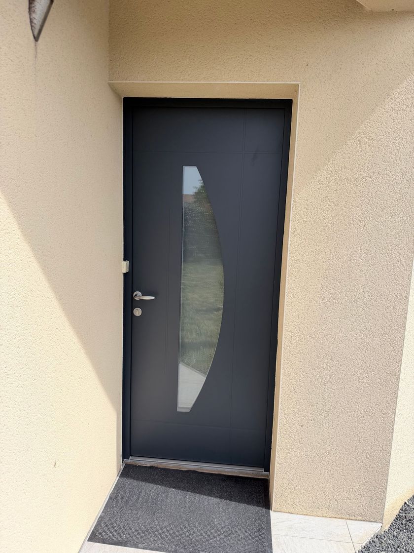 Une porte d'entrée noire avec une vitre.