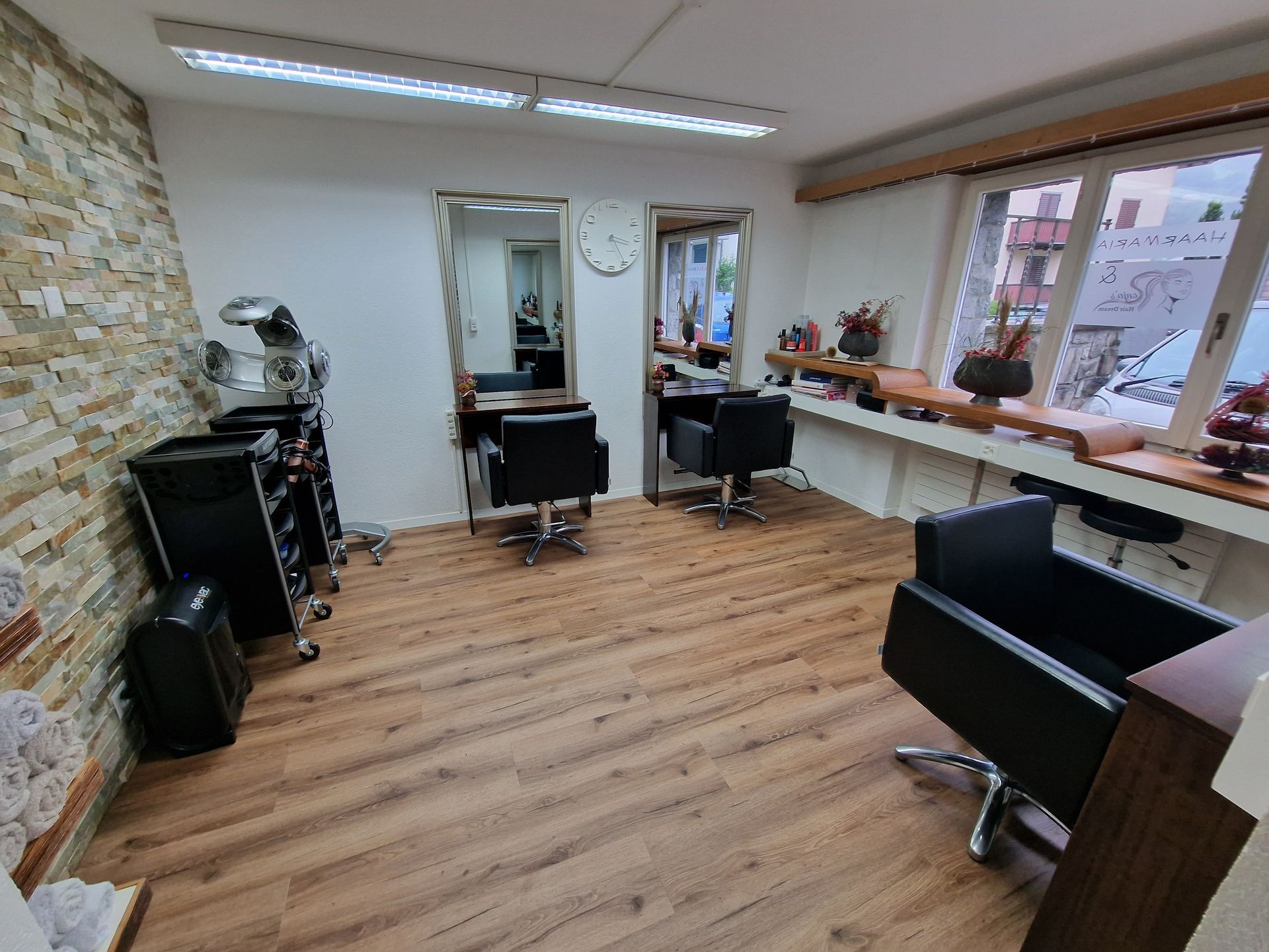 Friseursalon-Interieur mit Shampoo-Stuhl, Produktregalen und Fenster.