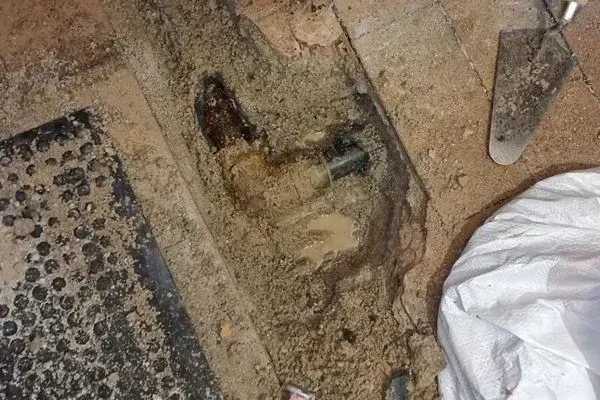 Una pala está en el suelo al lado de un trozo de madera.