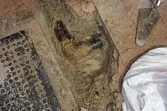 Una pala está en el suelo al lado de un montón de tierra.