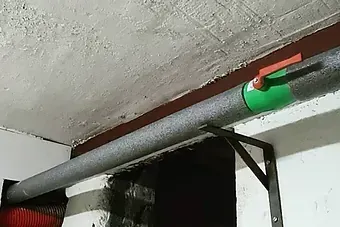 Una tubería verde cuelga del techo de una habitación.