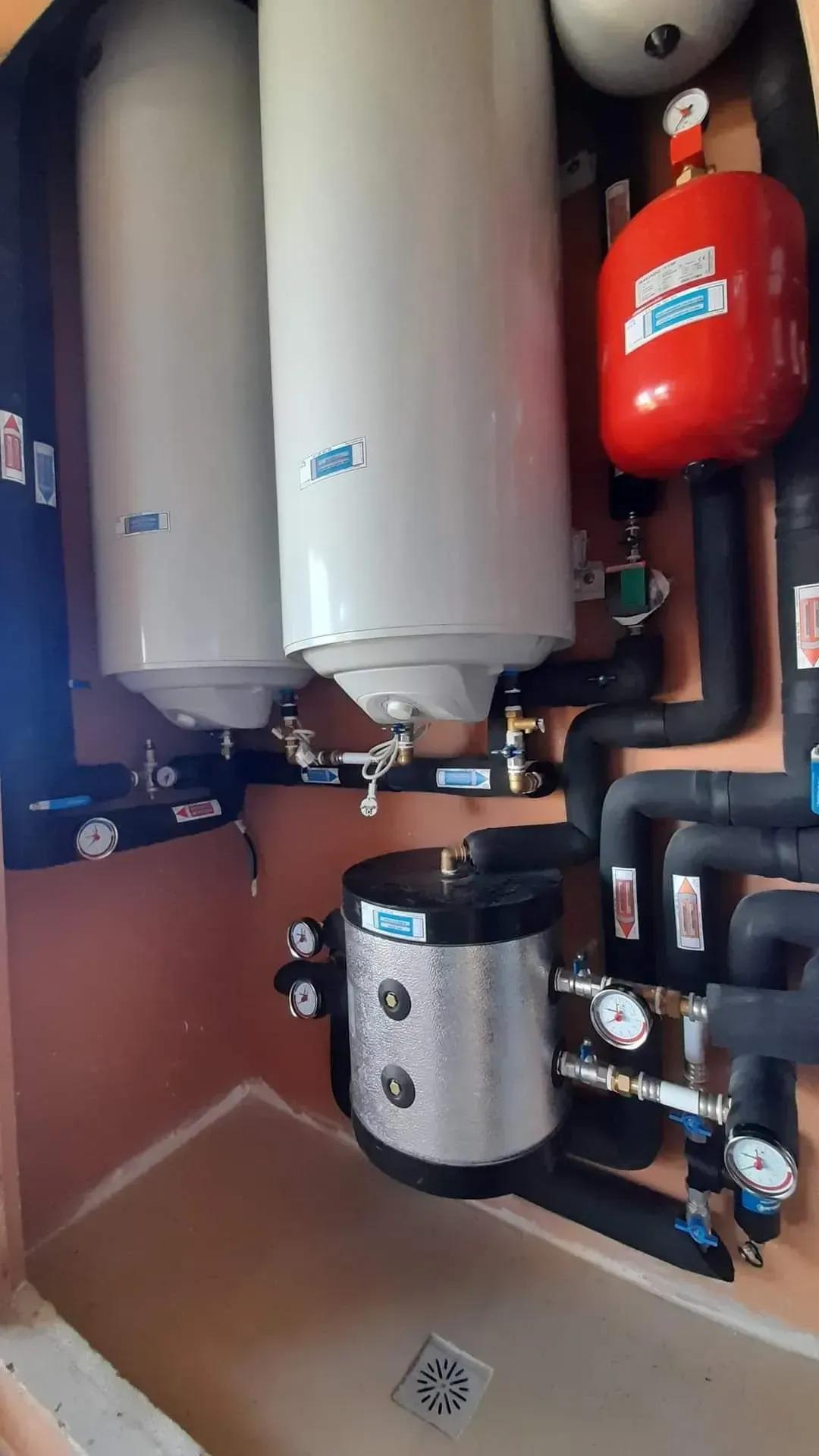 Una habitación con dos calentadores de agua y muchas tuberías.