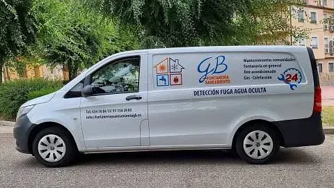 Una camioneta blanca está estacionada al costado de la carretera.
