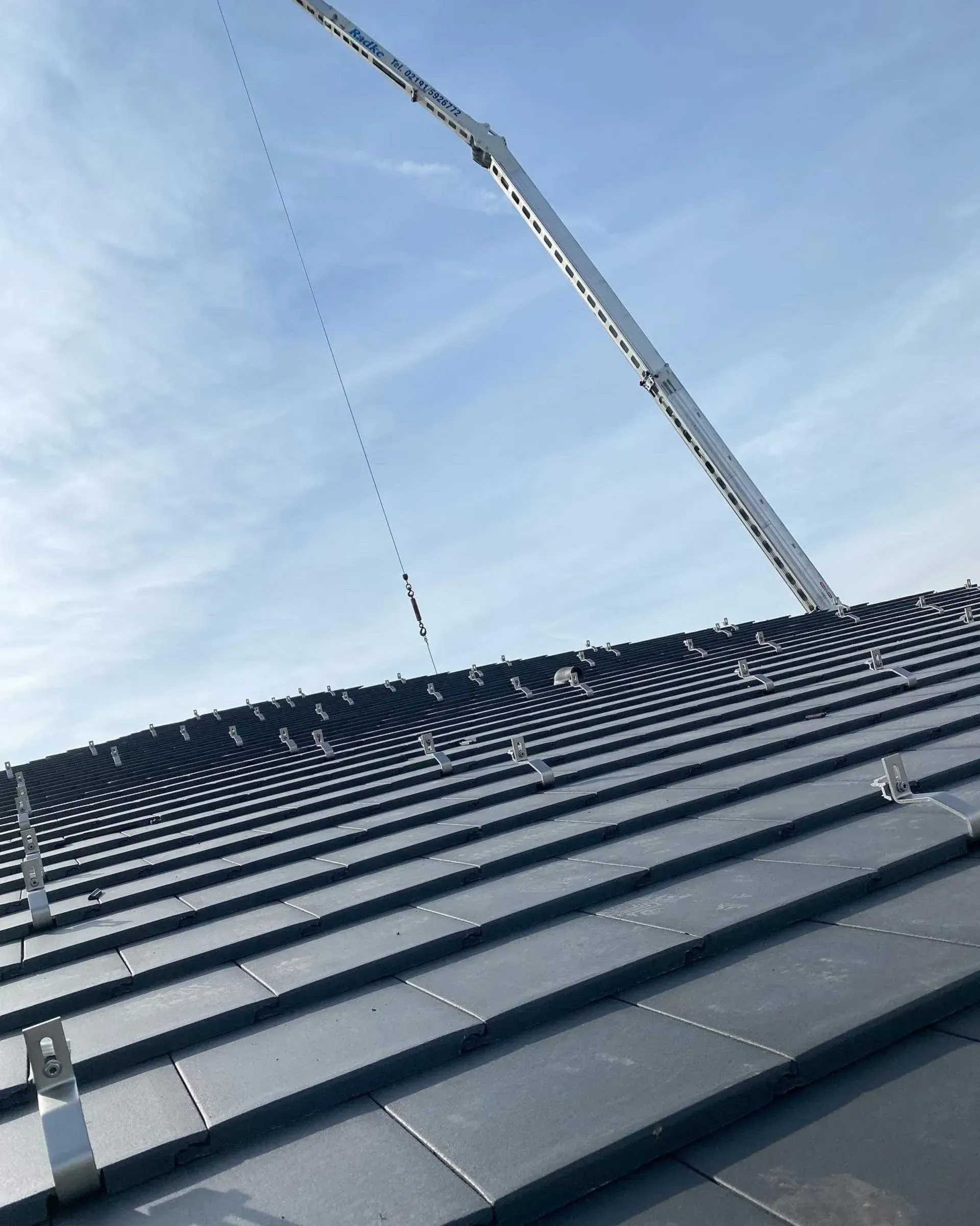 Nahaufnahme von einem Dach mit Kran im Hintergrund