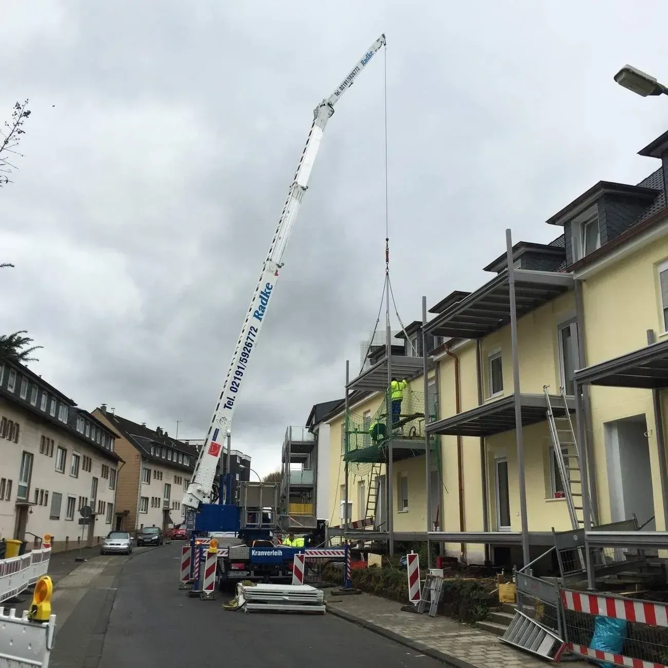 Kran der Firma Dachdeckermeister Radke in einer Wohnsiedlung
