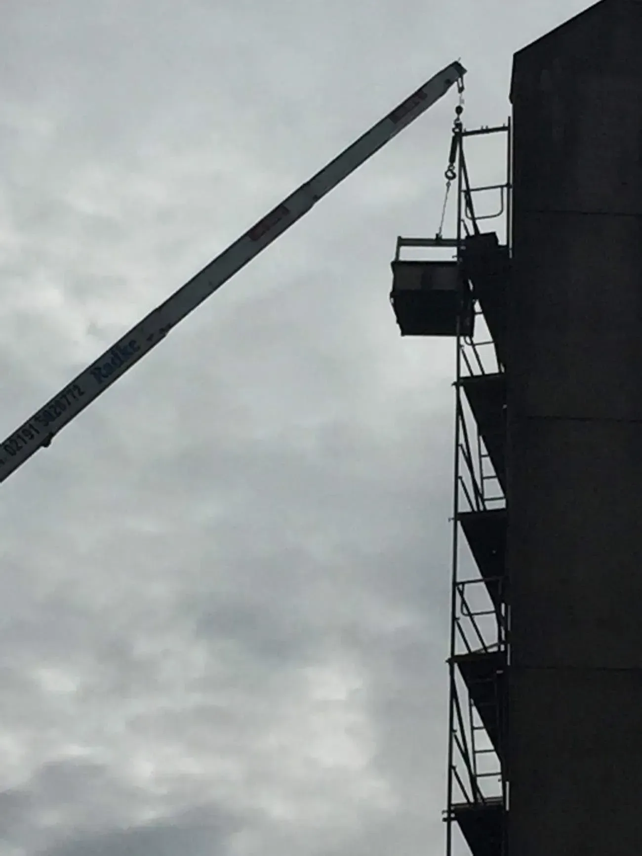 Kran der Firma Dachdeckermeister Radke an einem Schornstein