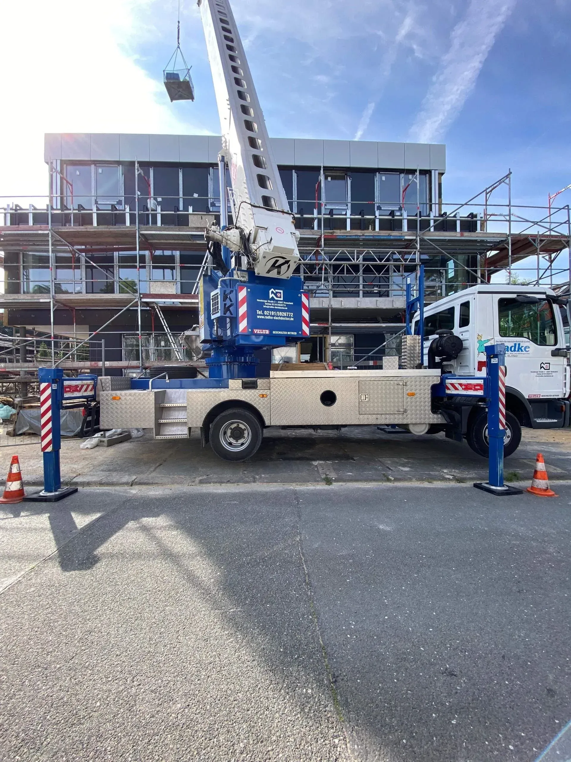 Kranfahrzeug vor Baugerüst der Firma Dachdeckermeister Radke