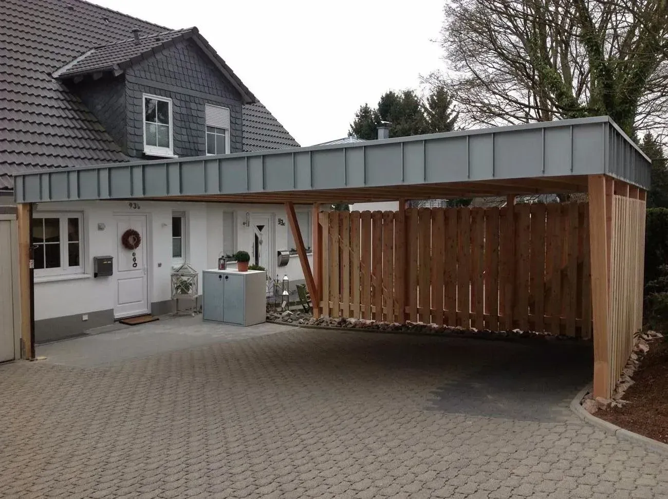 Carport mit Wänden aus Holzlatten