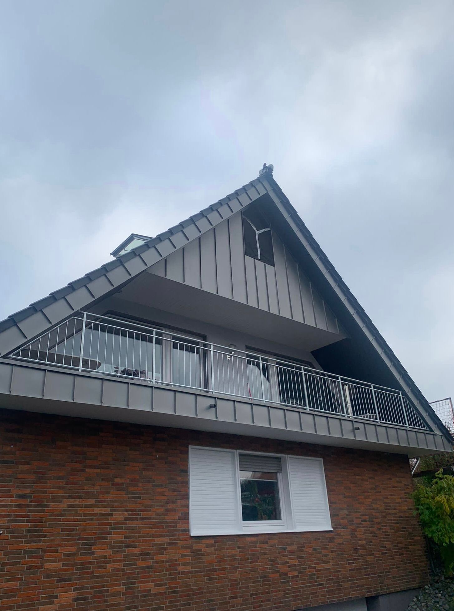 Freistehendes Haus mit Metallgiebel und Balkon