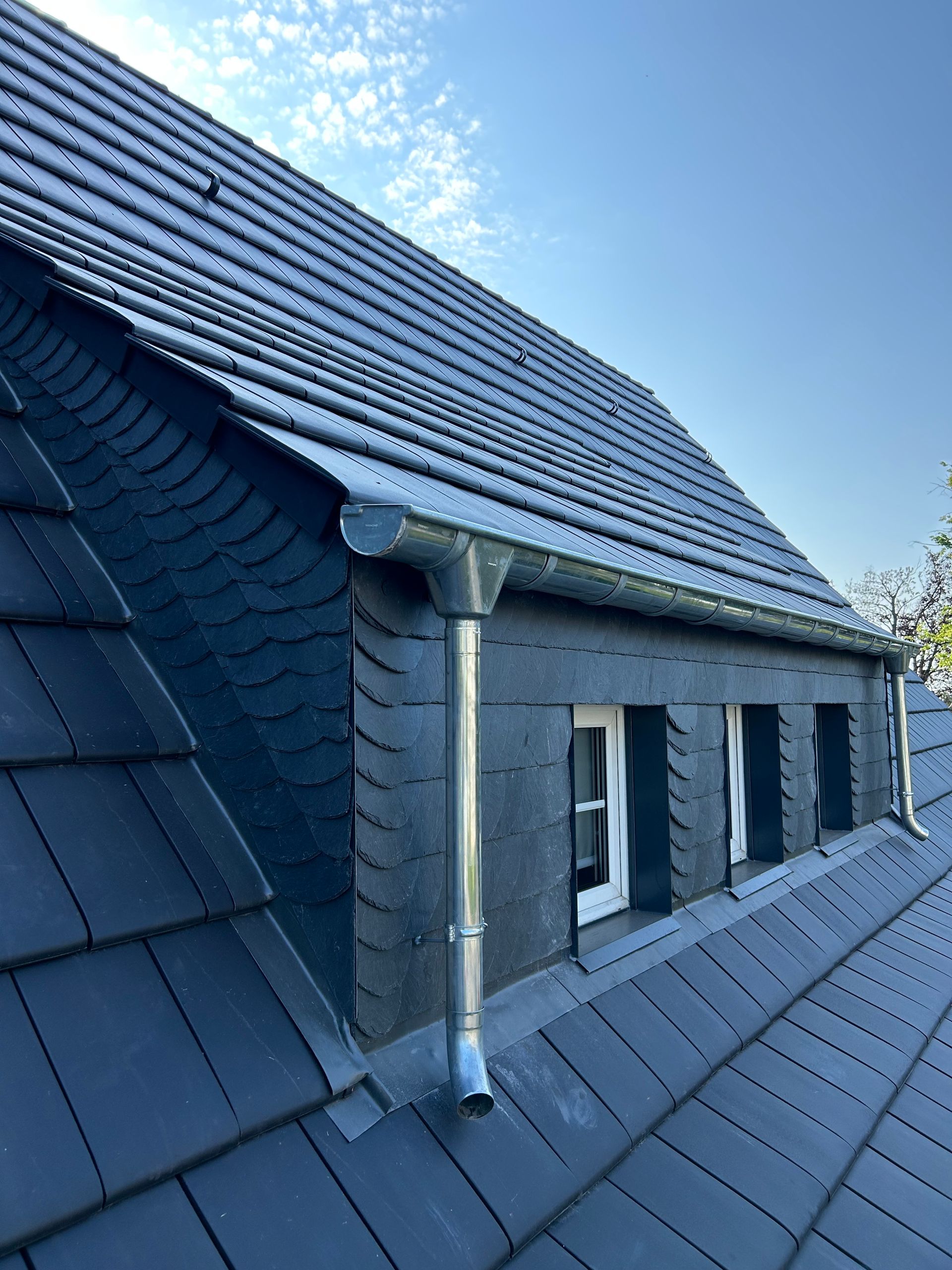 Steildach mit Fenstern eines dunklen Hauses