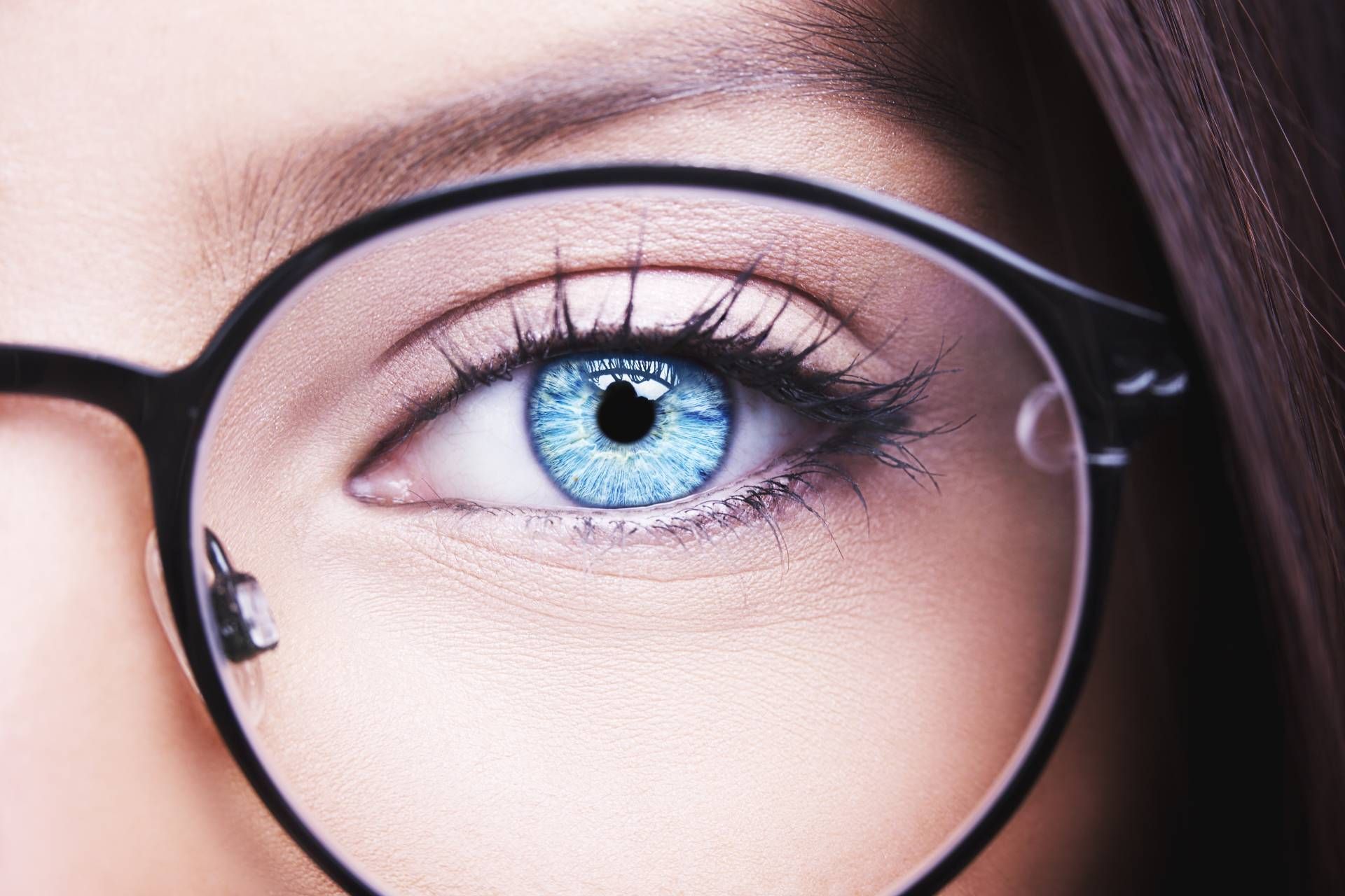 Nahaufnahme eines blauen Auges einer Frau mit Brille