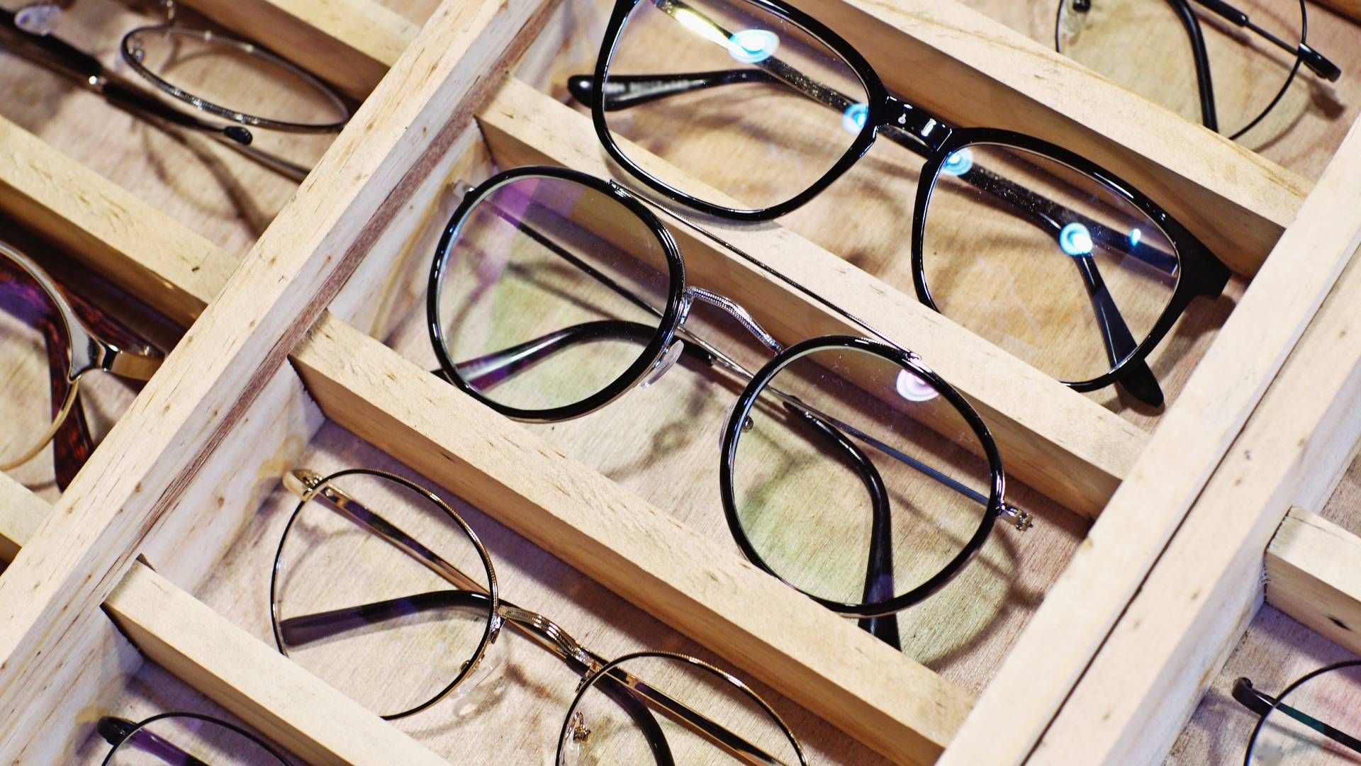 eine Auswahl an Brillengläsern in einer Holzkiste