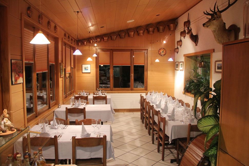 Un ristorante con tavoli e sedie e una testa di cervo sul muro