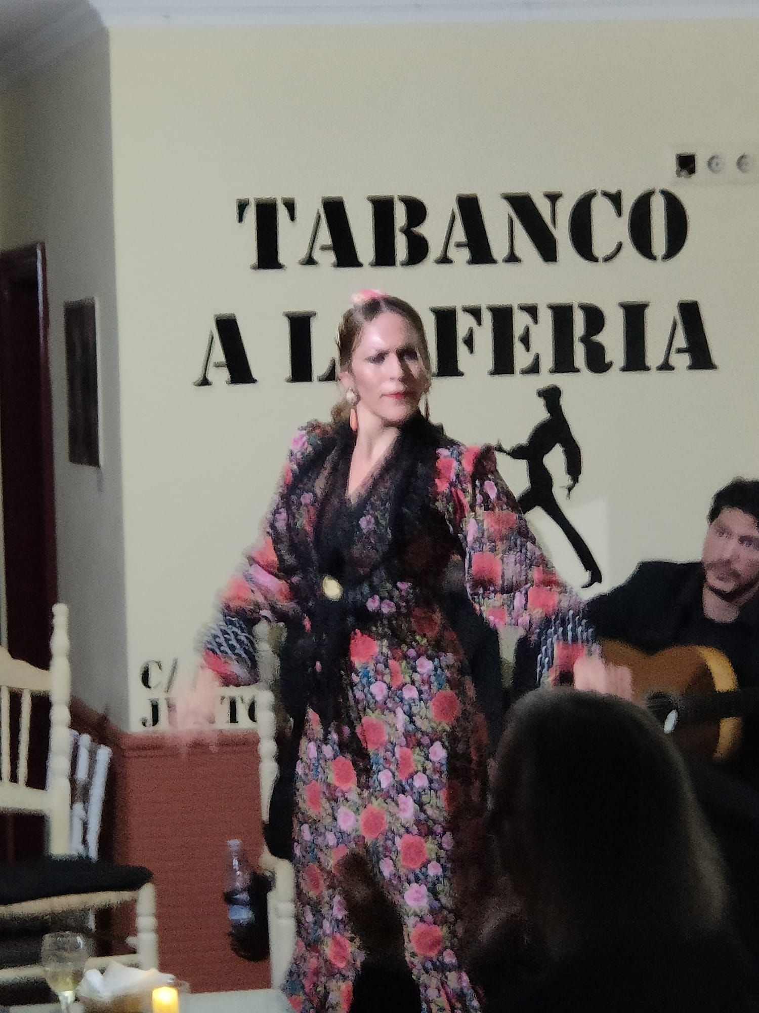 Una mujer está bailando frente a un cartel que dice 