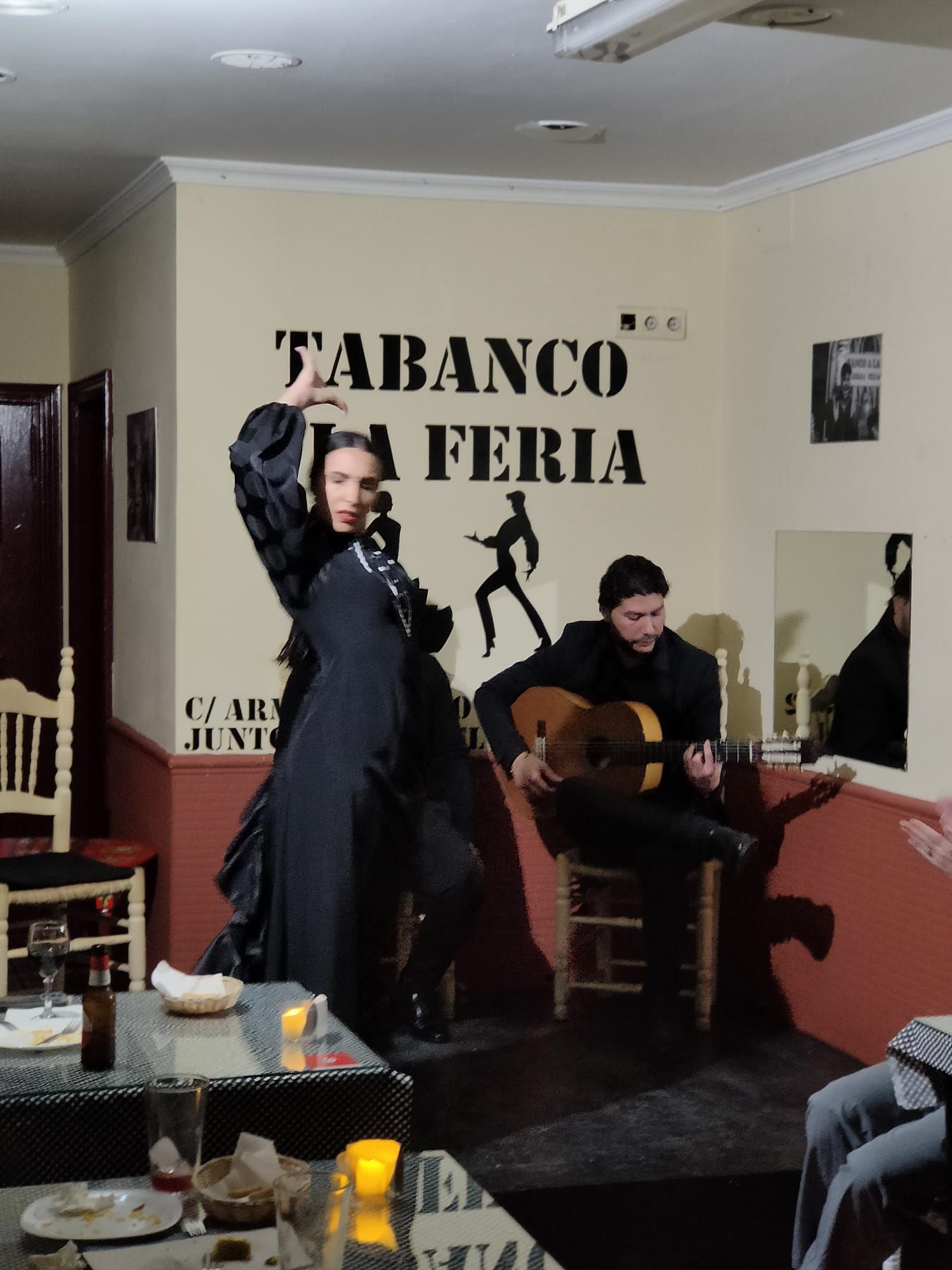Una mujer está bailando frente a un cartel que dice 