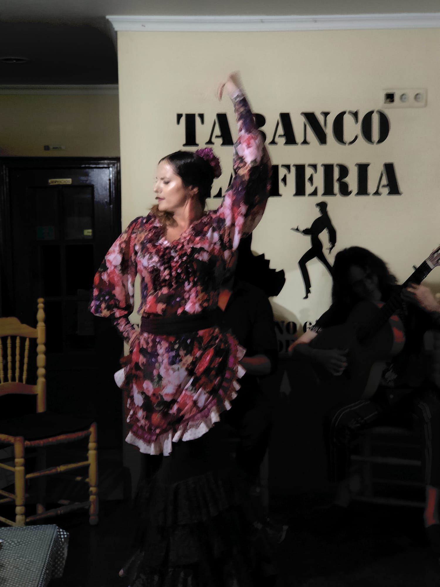 Una mujer está bailando frente a un cartel que dice 
