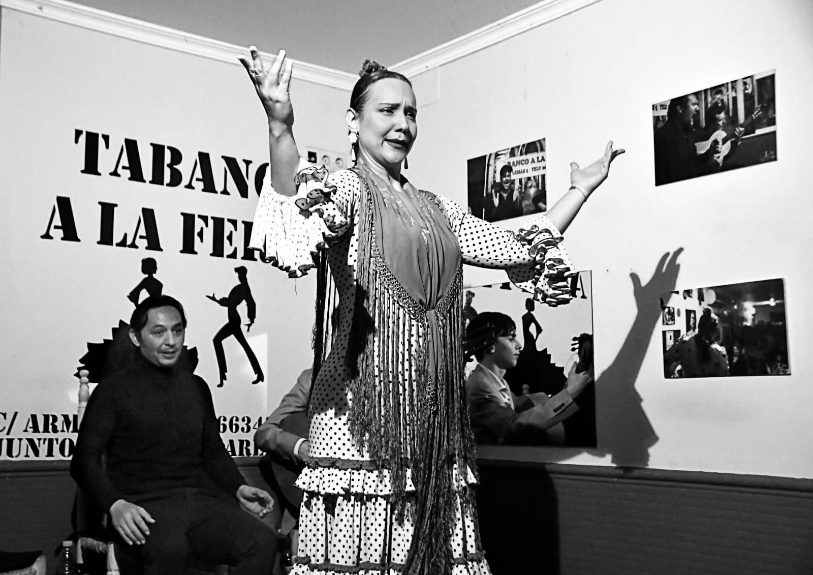 Una mujer está bailando frente a un cartel que dice tabano a la fel