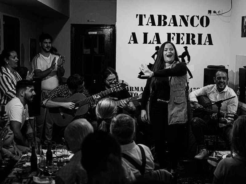 Una fotografía en blanco y negro de un grupo de personas tocando guitarras en una habitación.