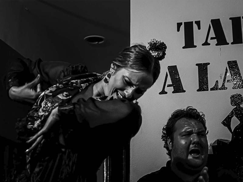Una mujer está bailando frente a un cartel que dice ta ala