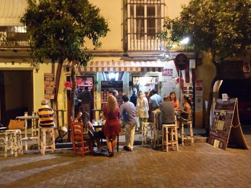 Un grupo de personas sentadas en mesas afuera de un restaurante.