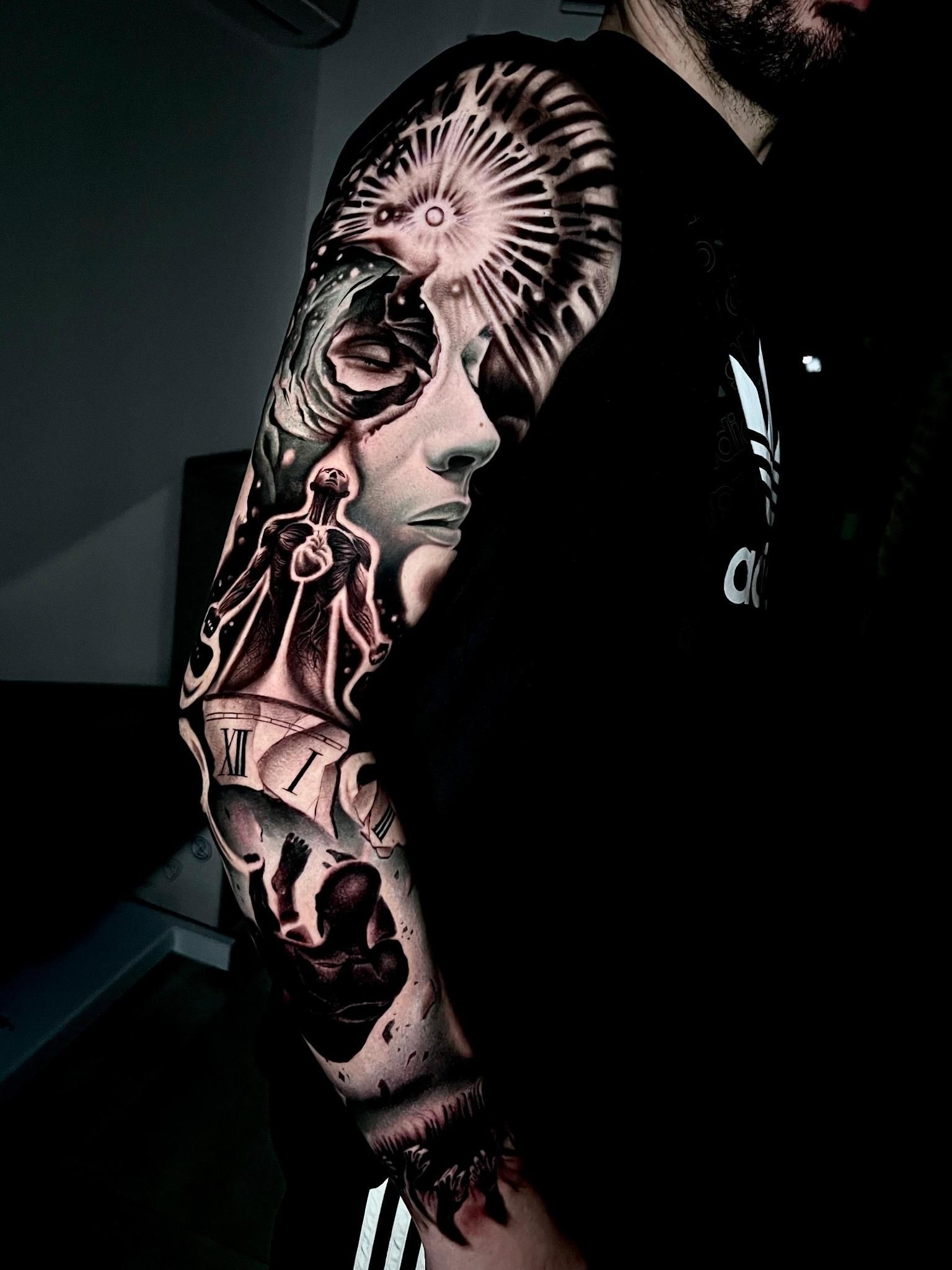 Un hombre con un tatuaje en toda la manga del brazo.