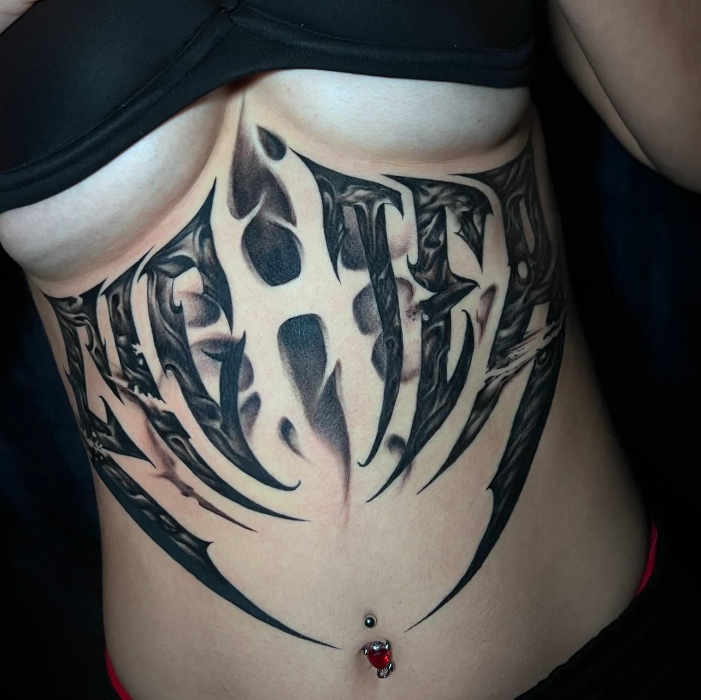 Una mujer tiene un gran tatuaje en el estómago.