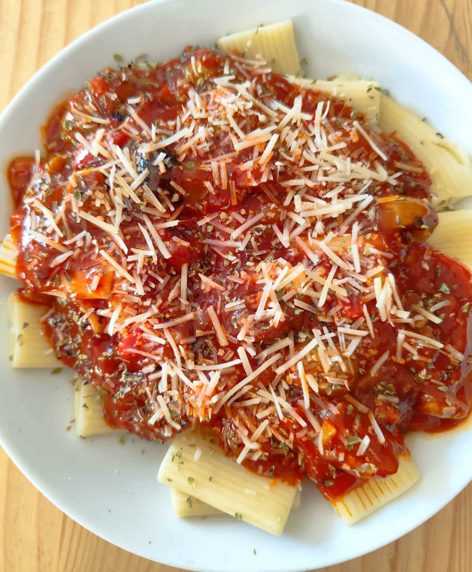 Pasta con salsa roja y queso parmesano rallado.