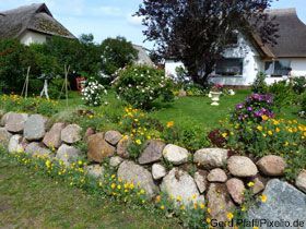 Beete mit Natursteinen und Blumen